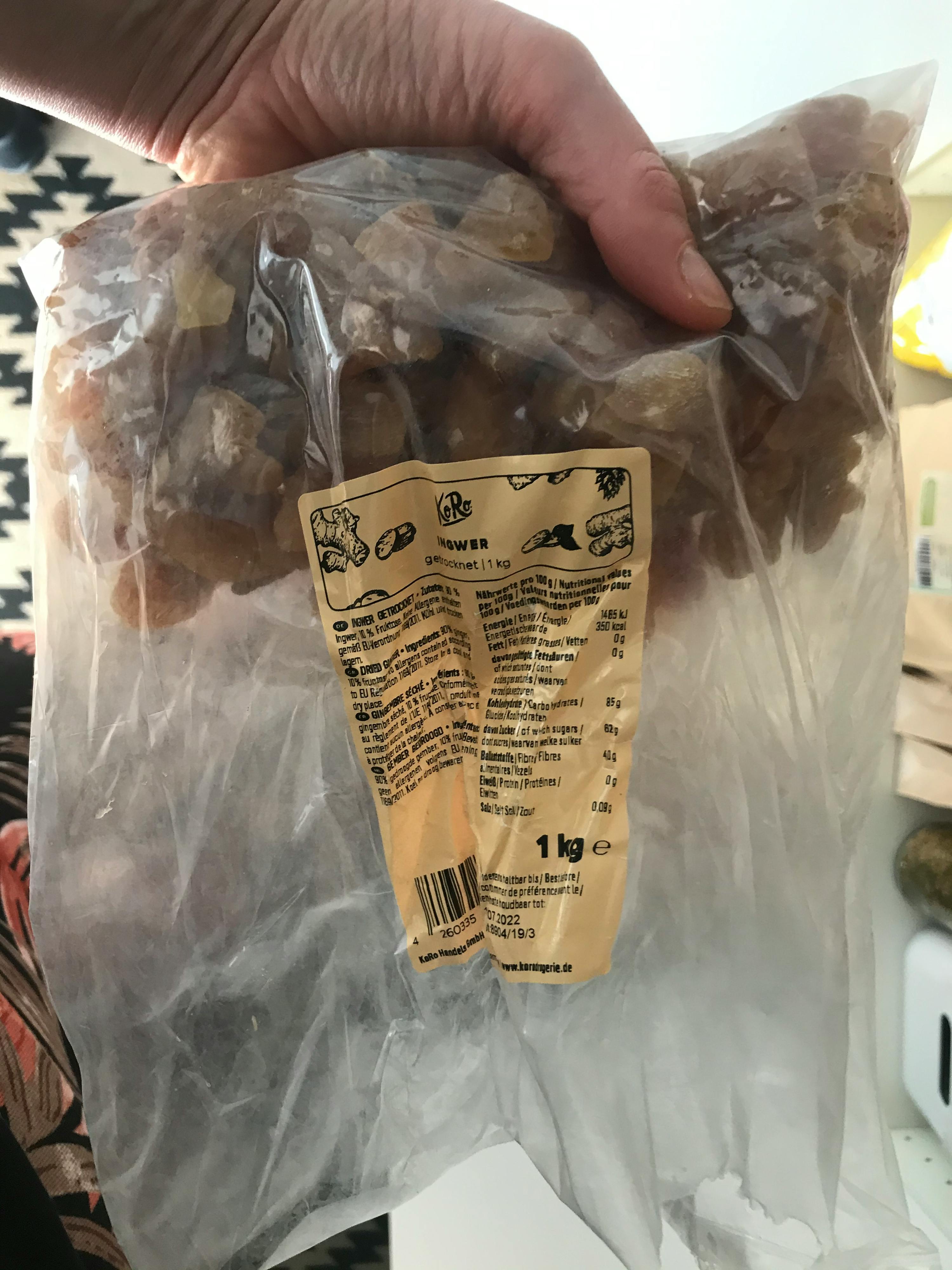 a person holding a bag of raisins with a label that says 1 kg