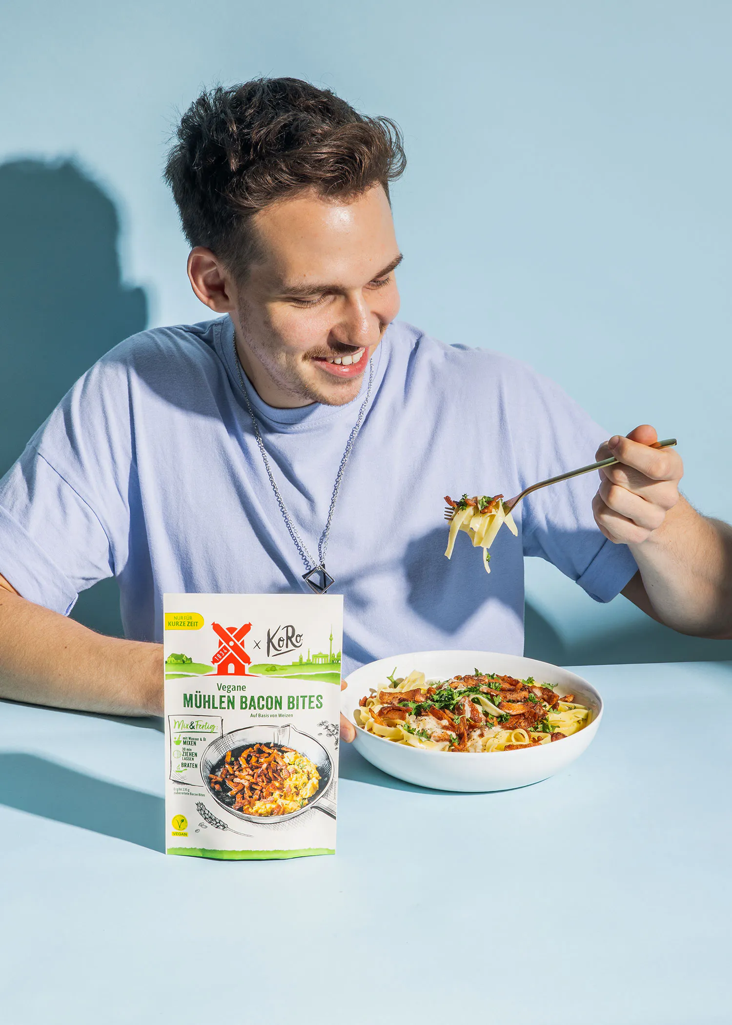 a man is eating a meal from a box of muhlen bacon bites