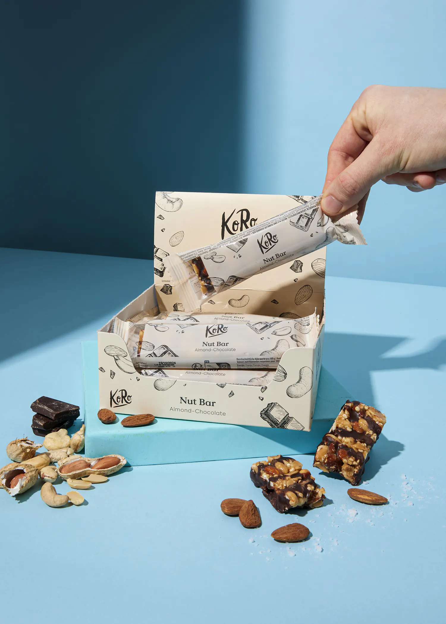 une personne tient une barre de noix à côté d' une boîte de noix