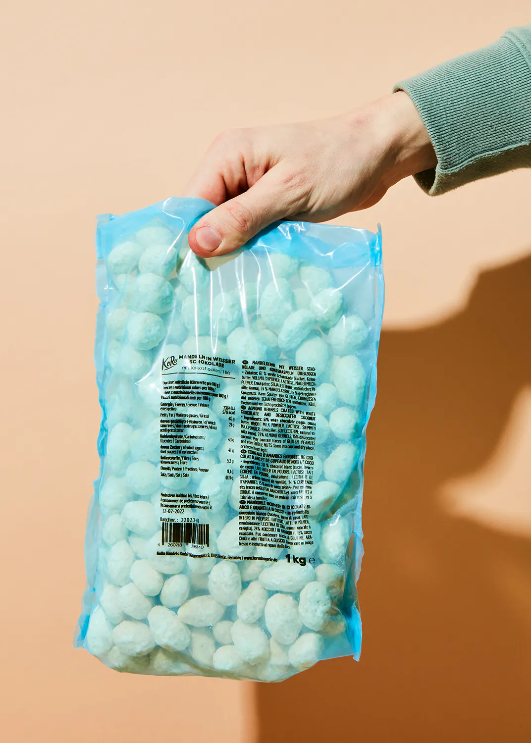 a person is holding a bag of candy that says 1 kg on it