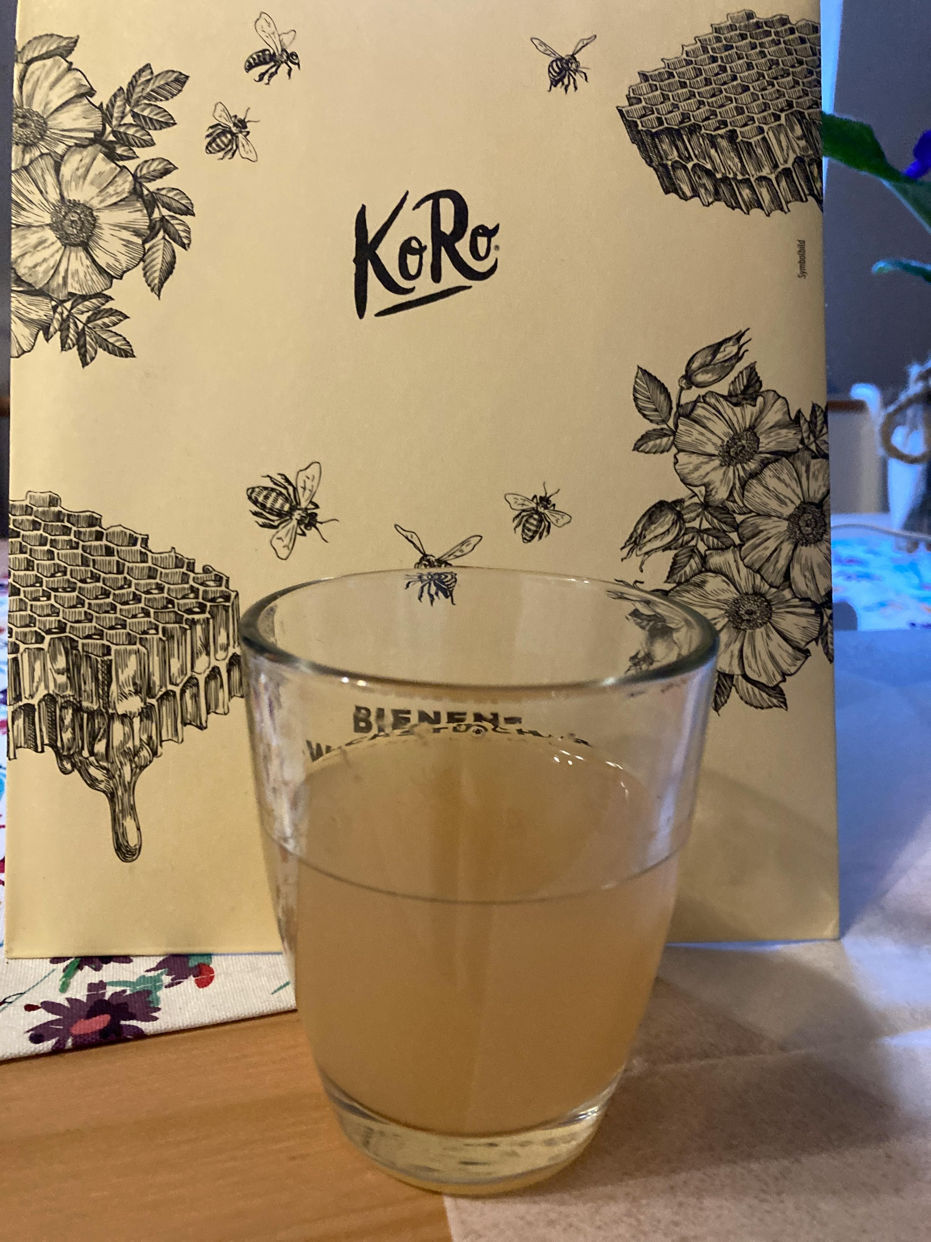 un verre est assis sur une table à côté d' une boîte de koré
