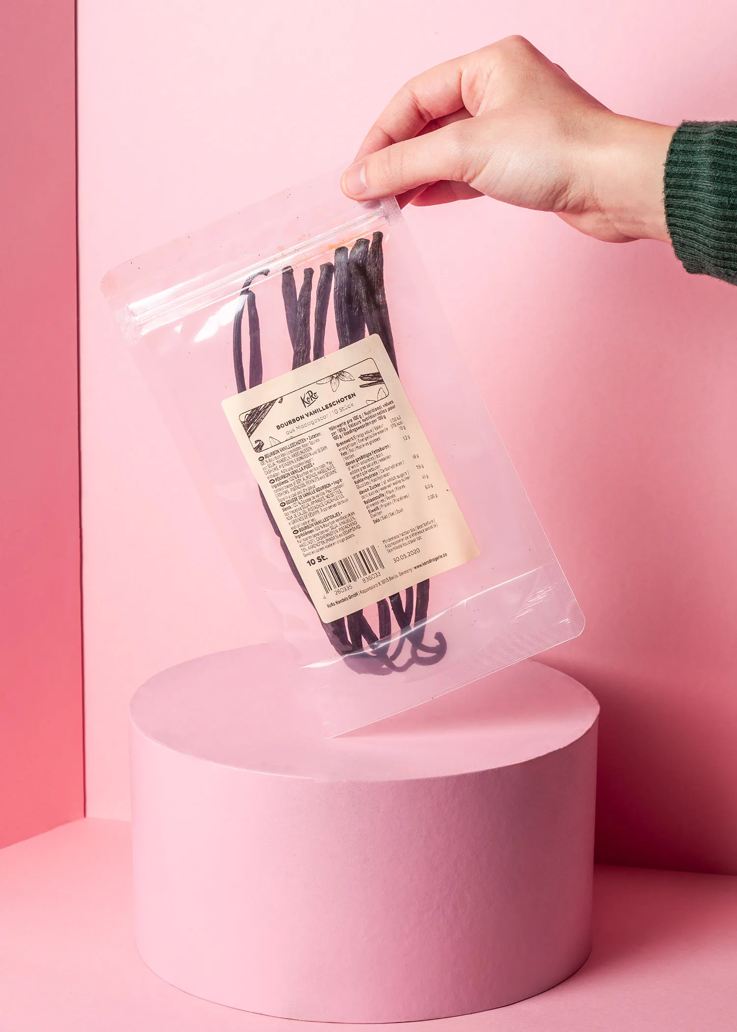 eine Person hält einen Plastikbeutel mit vanilleschoten in der Hand