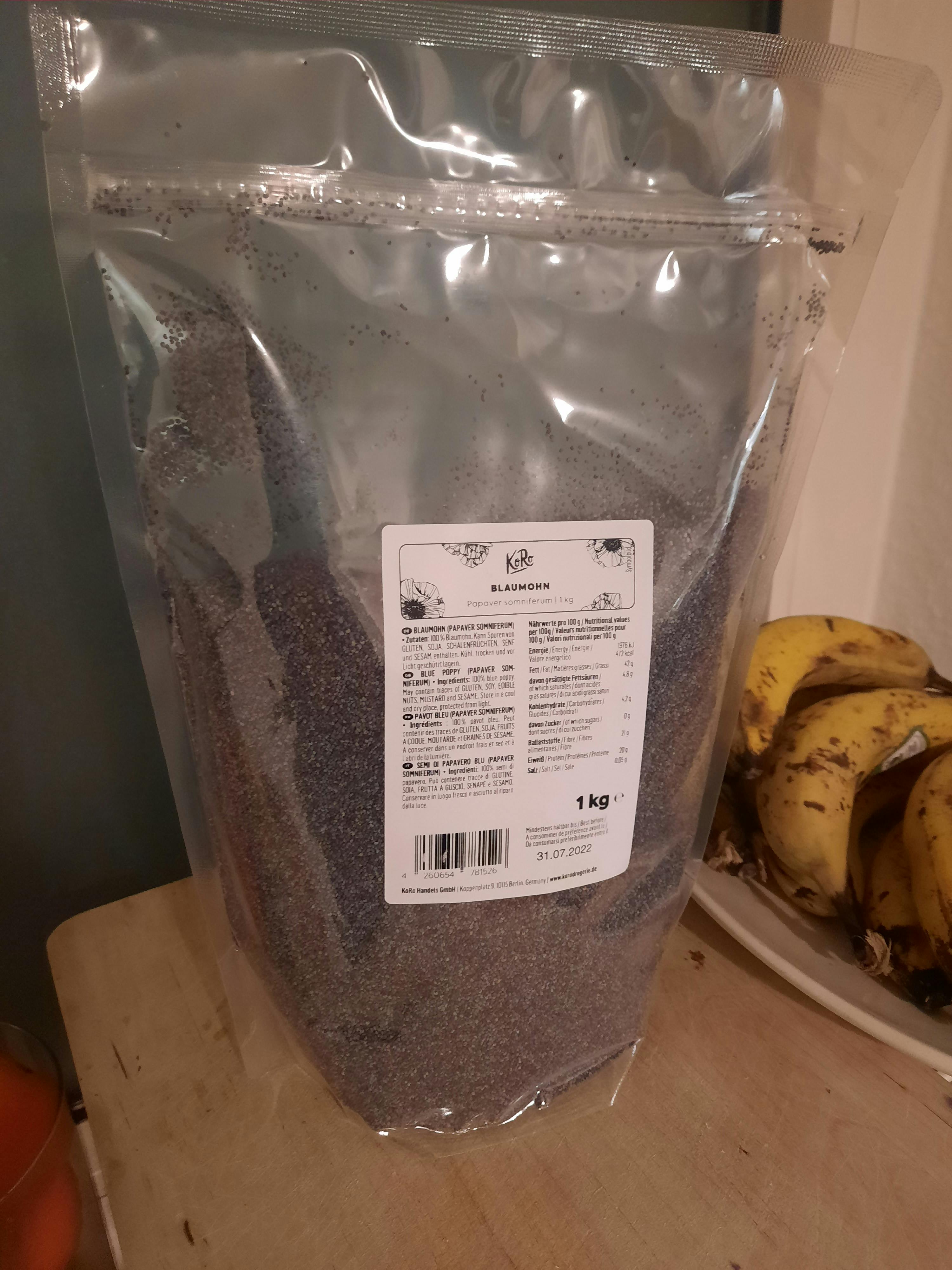 a bag of poppy seeds sits on a table next to bananas