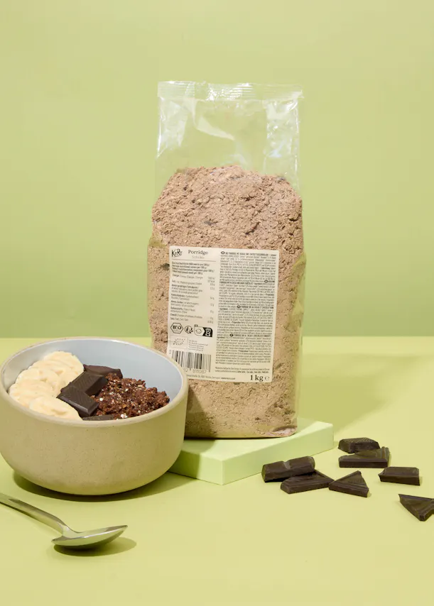 eine Schüssel Müsli mit Schokoladenstücken neben einem Paket Müsli