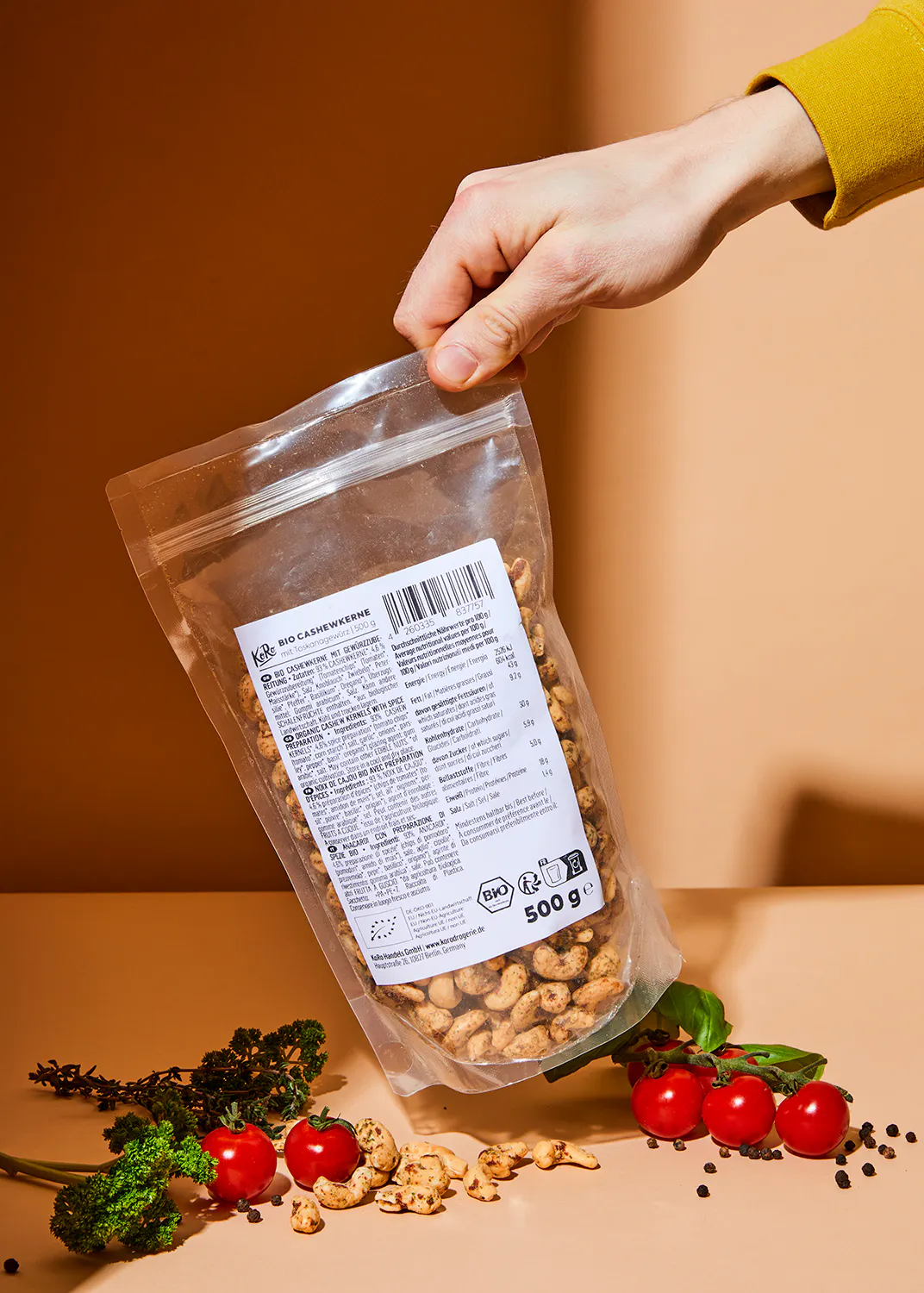 une personne tient un sac de noix de cajou sur une table