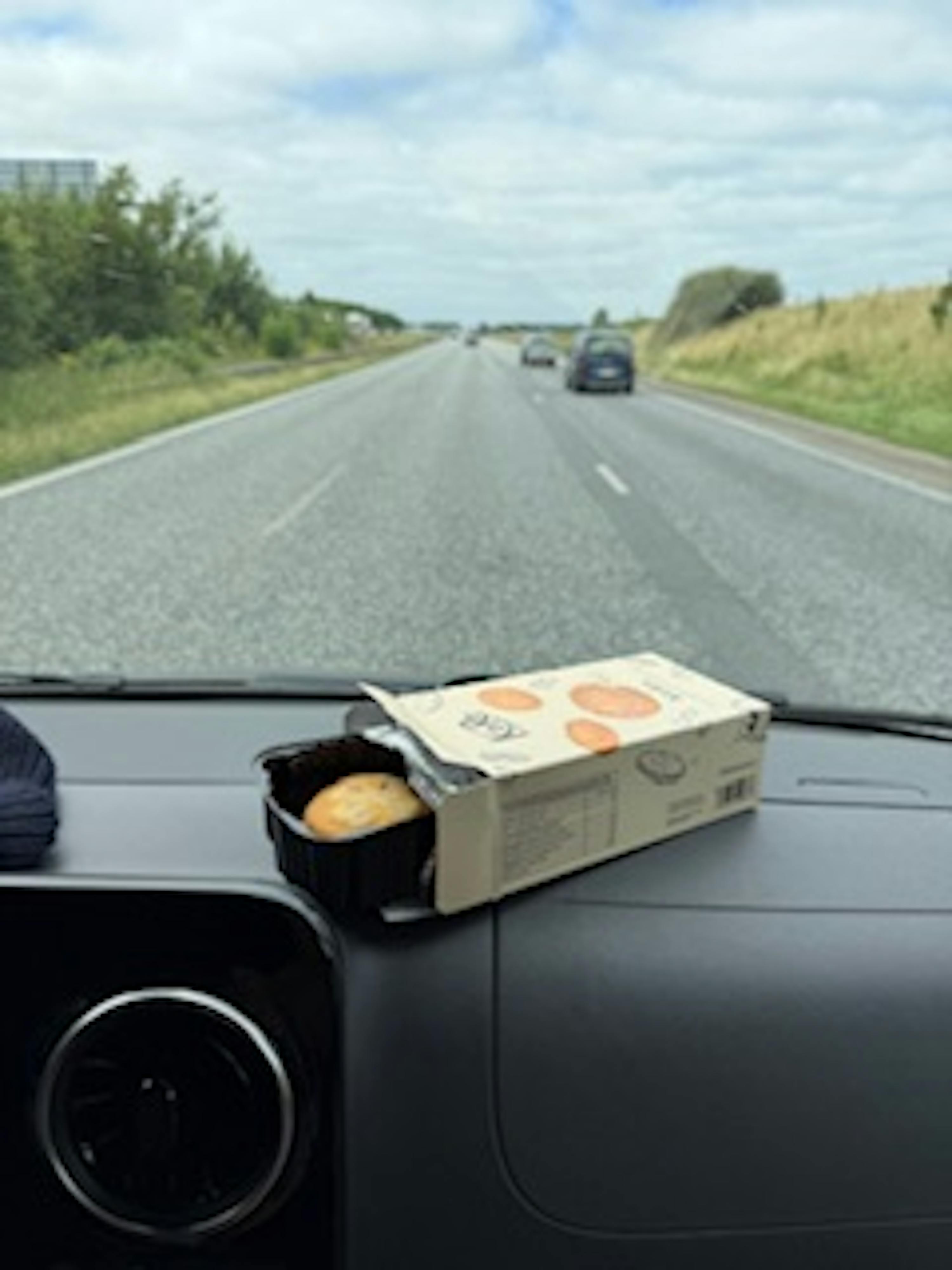 une boîte de biscuits est sur le tableau de bord d' une voiture