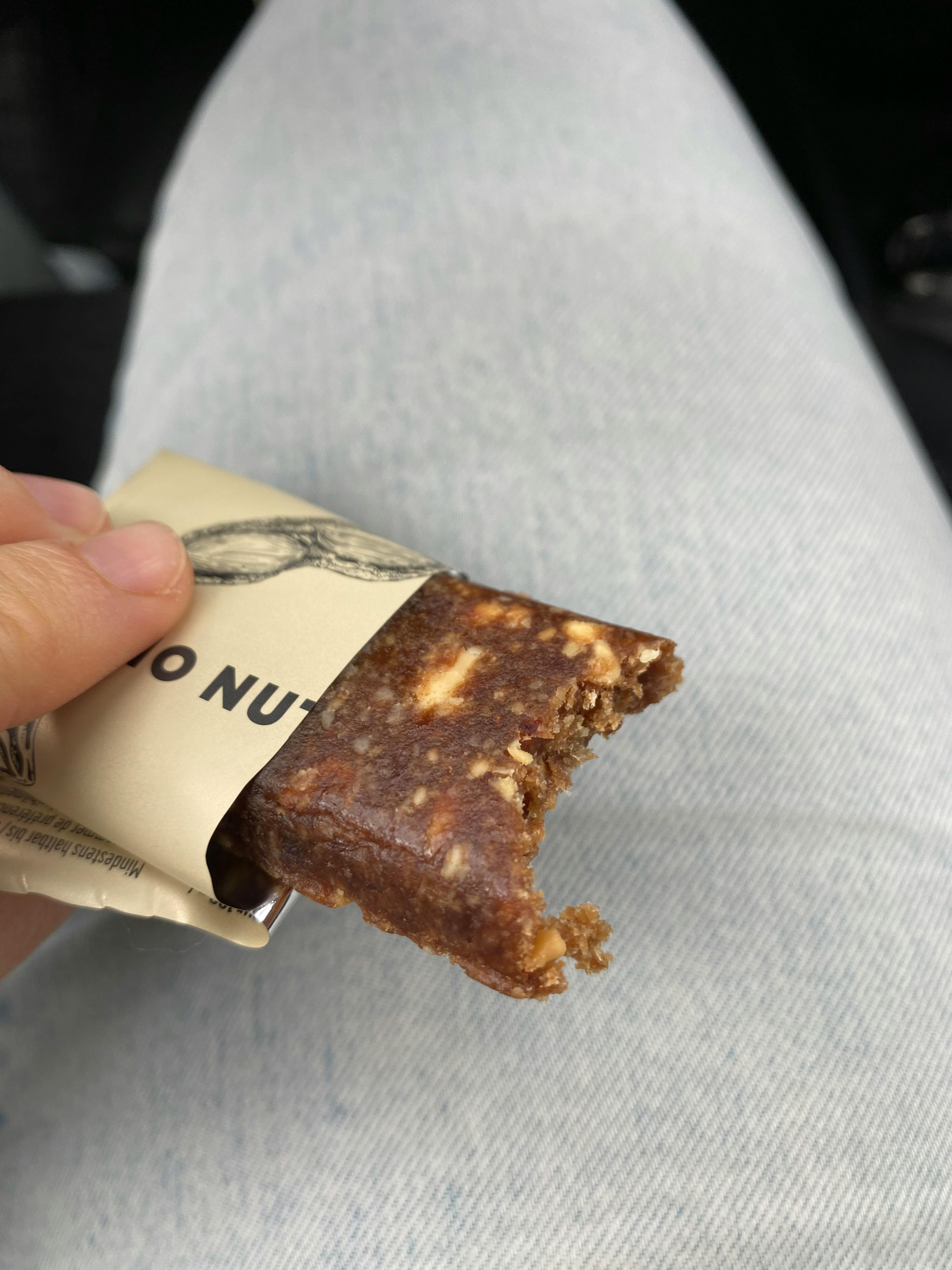 eine Person hält einen Nuss-Snack mit einem Stück genommen