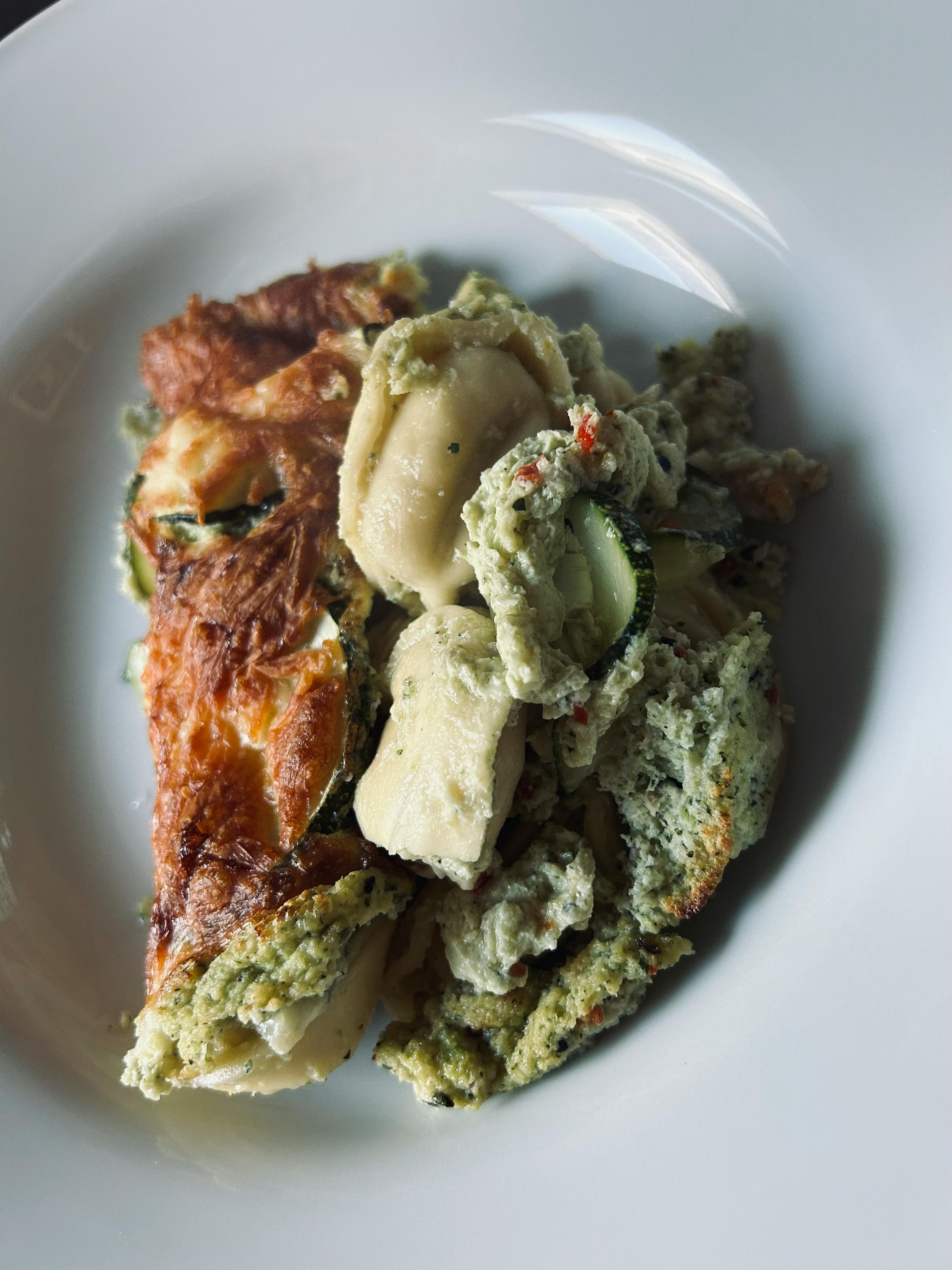 a white plate topped with a casserole of vegetables