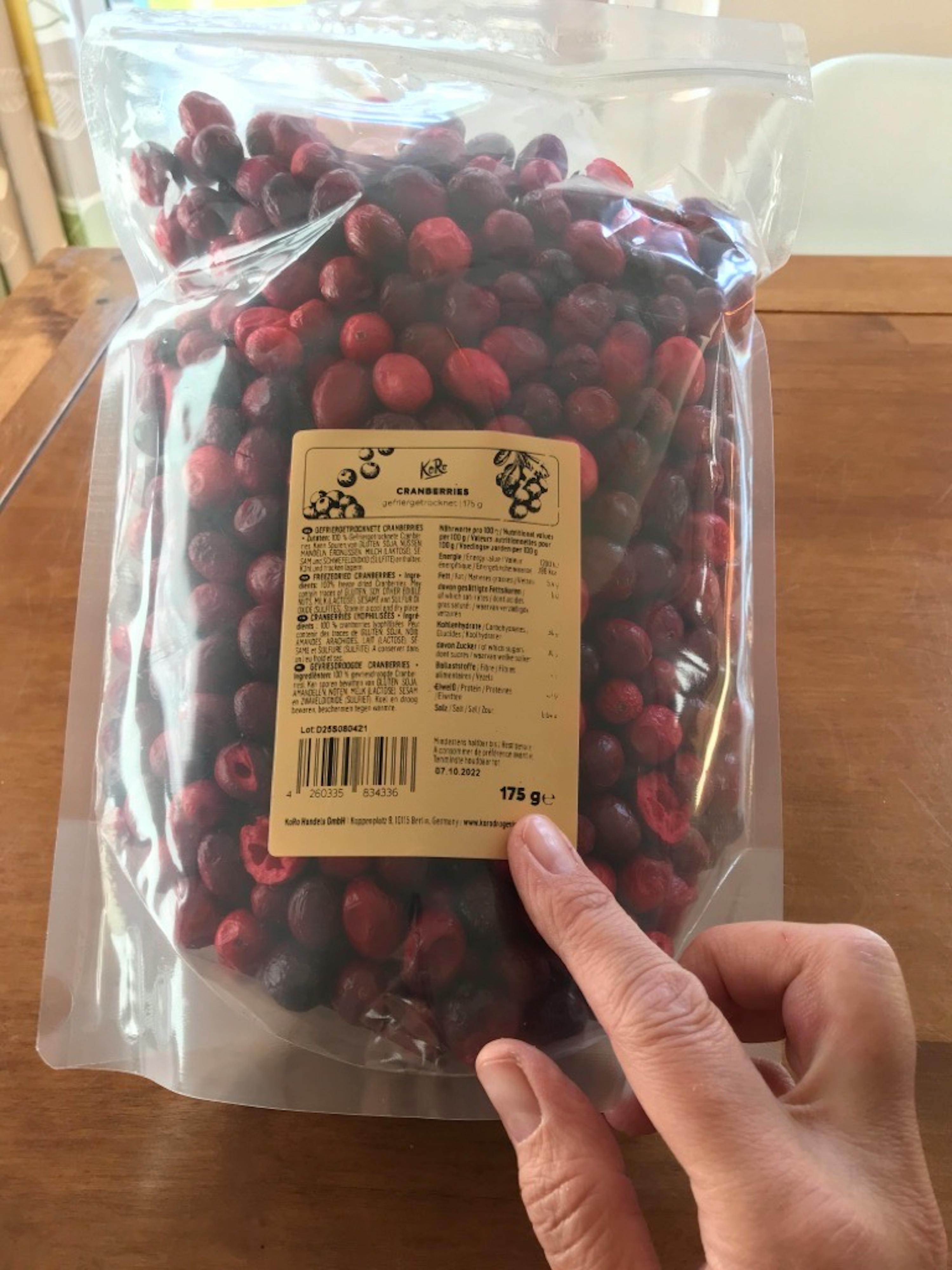 a bag of cranberries is being held by a person