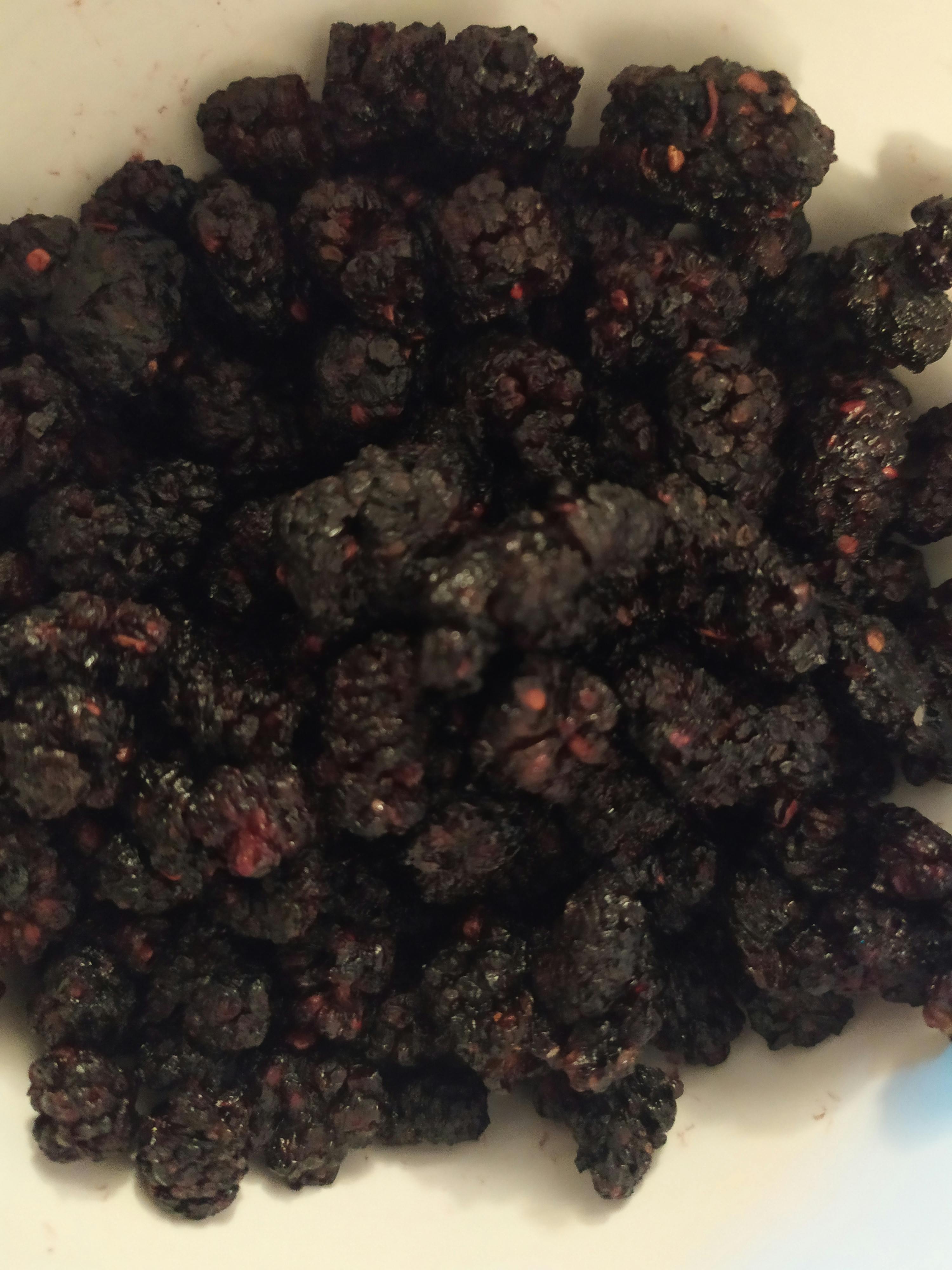 eine Nahaufnahme einer Schüssel mit schwarzen Beeren