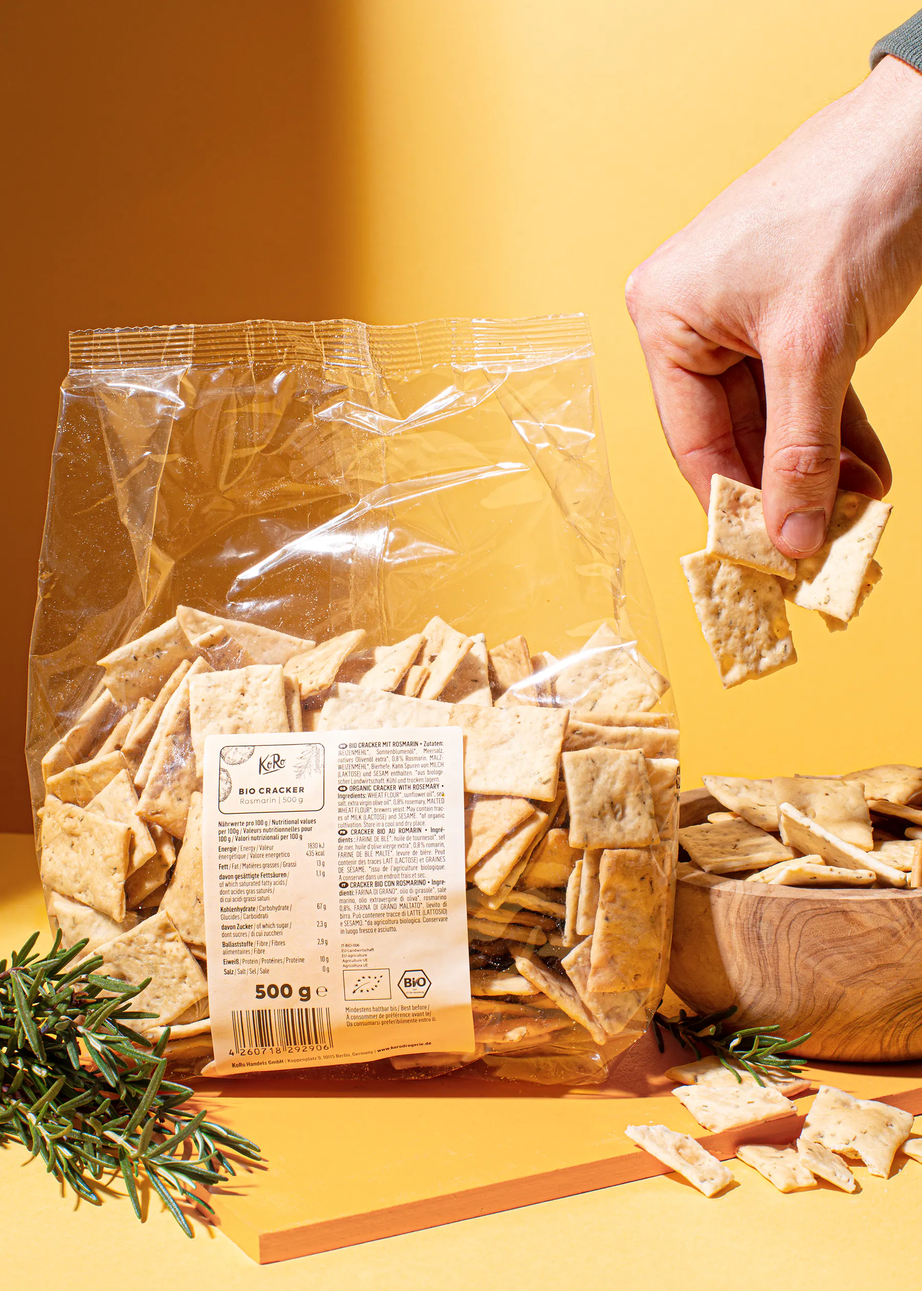 a hand reaches for a cracker from a bag of bio crackers