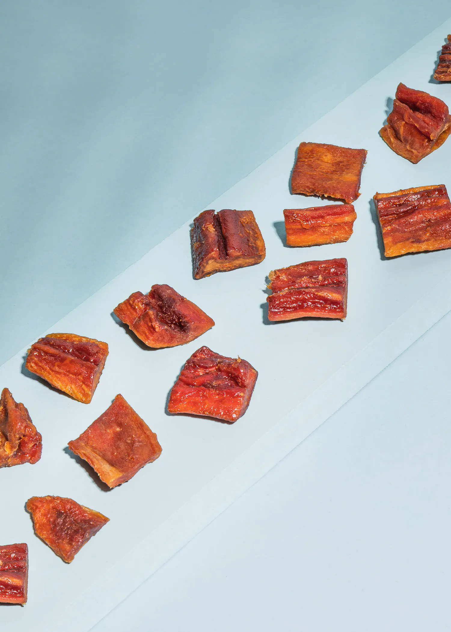 a bunch of slices of bacon on a blue surface