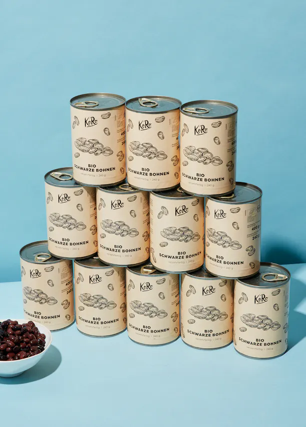 a stack of cans of bio schwarze bohnen on a blue background