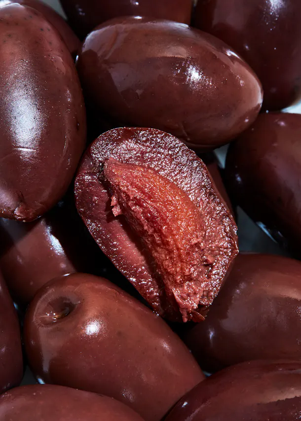 a pile of olives with one being cut in half