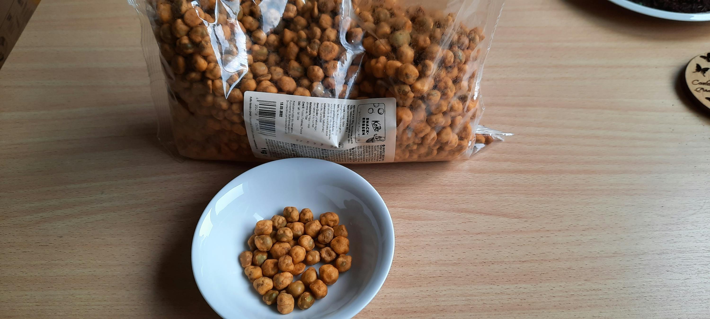 un sacchetto di arachidi e una ciotola di arachidi su un tavolo di legno