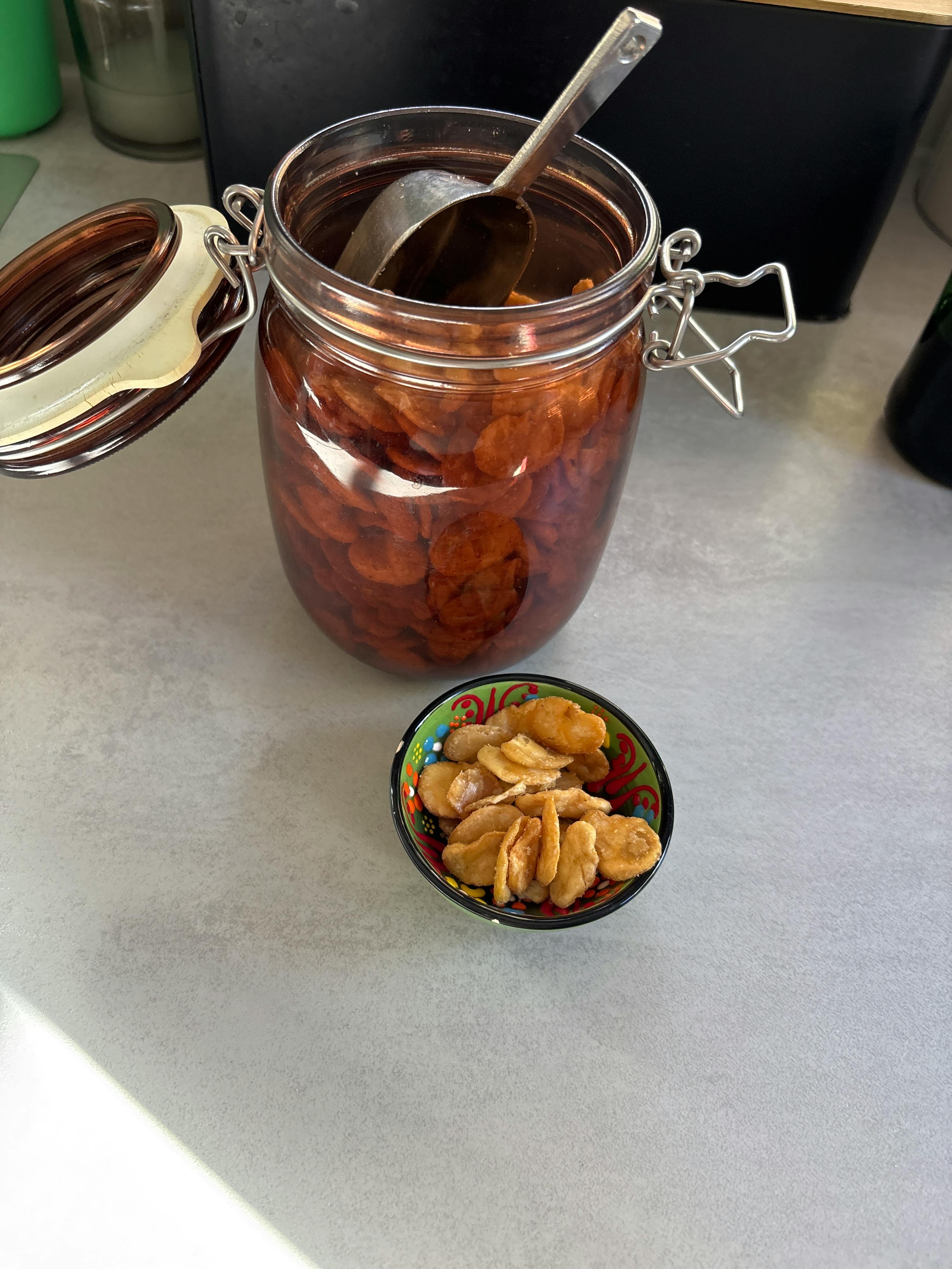 a jar filled with nuts next to a bowl of nuts