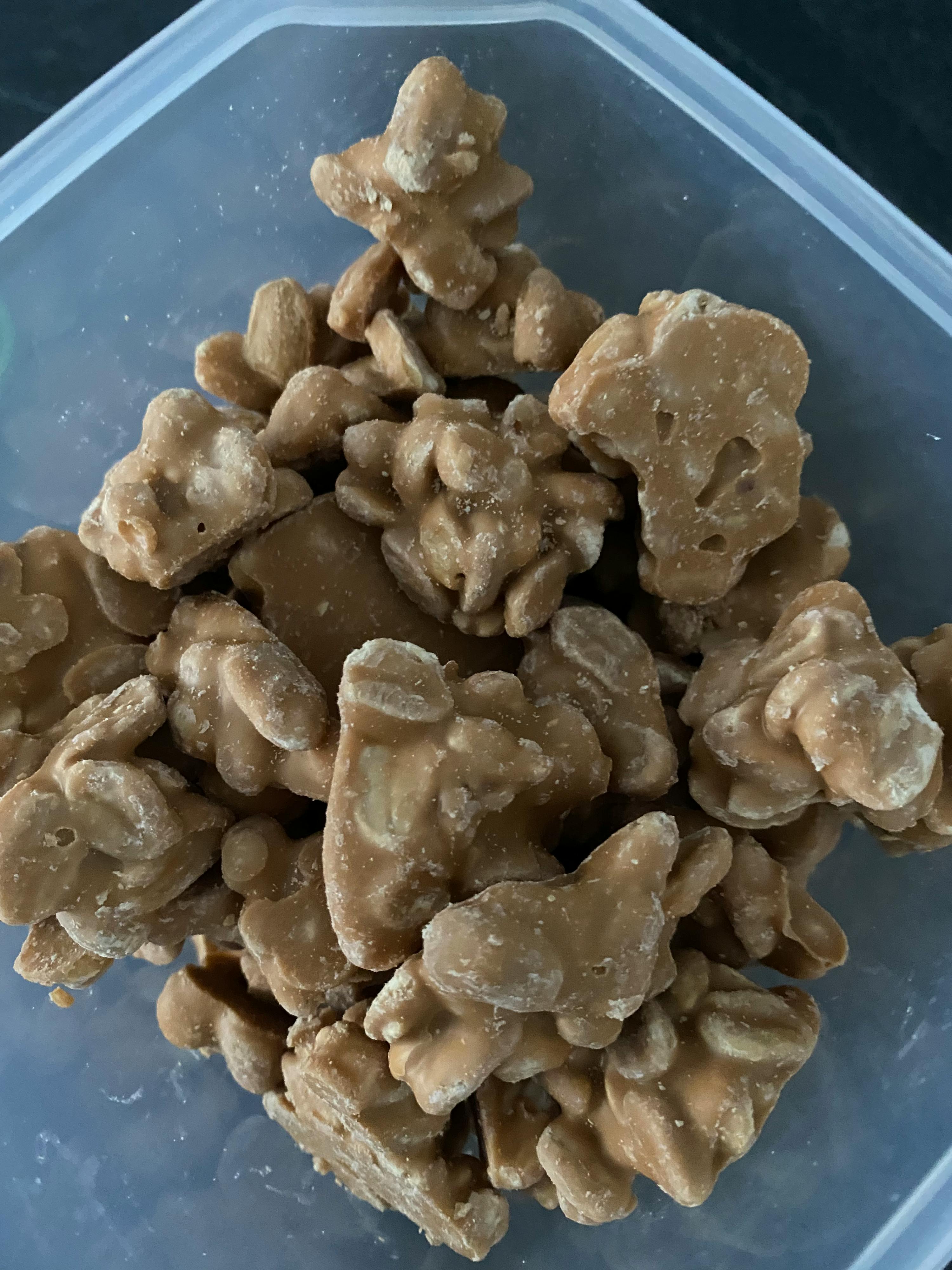 un contenitore di plastica pieno di noci caramellate