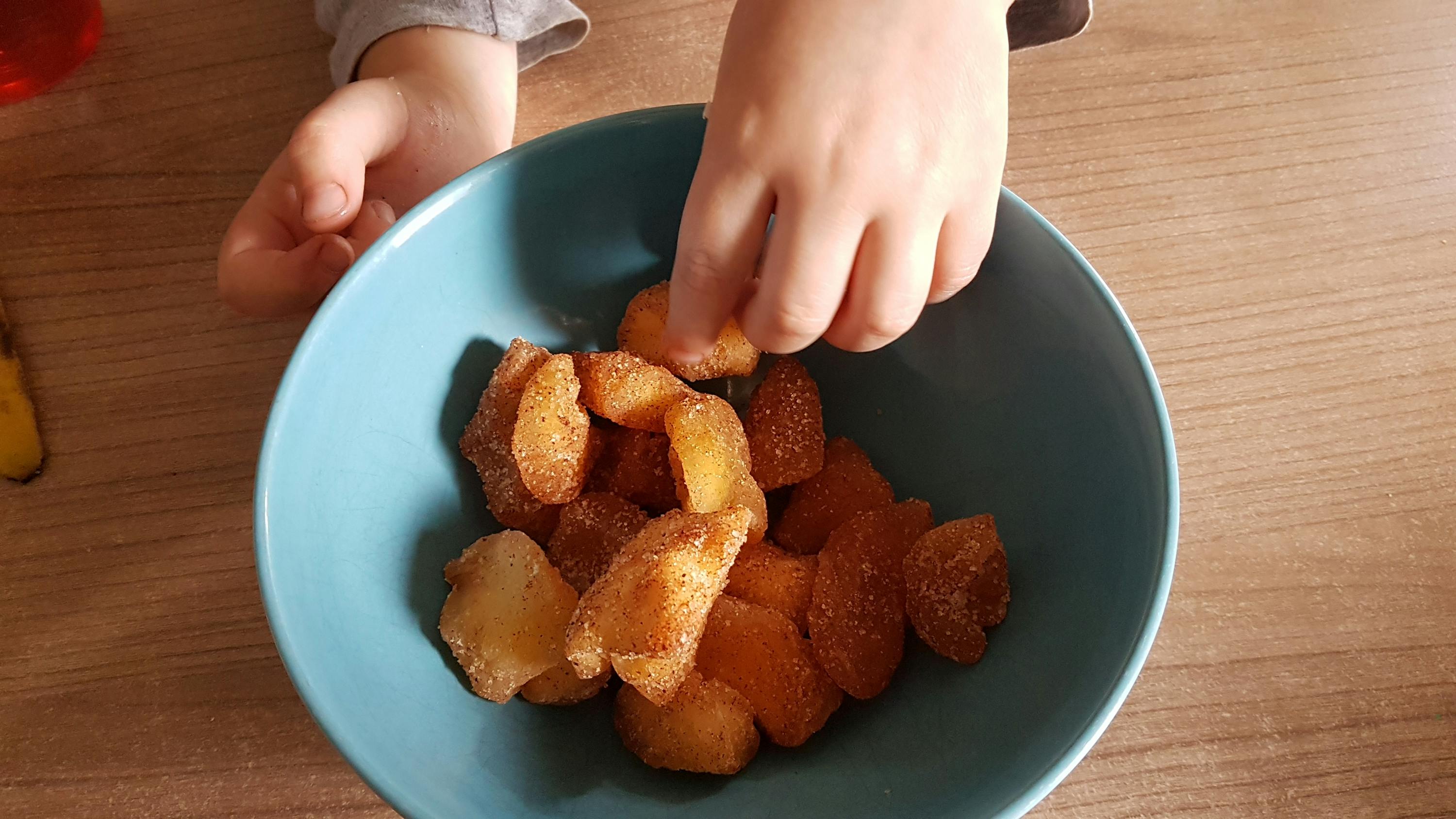 un enfant joue avec un bol de pommes frites