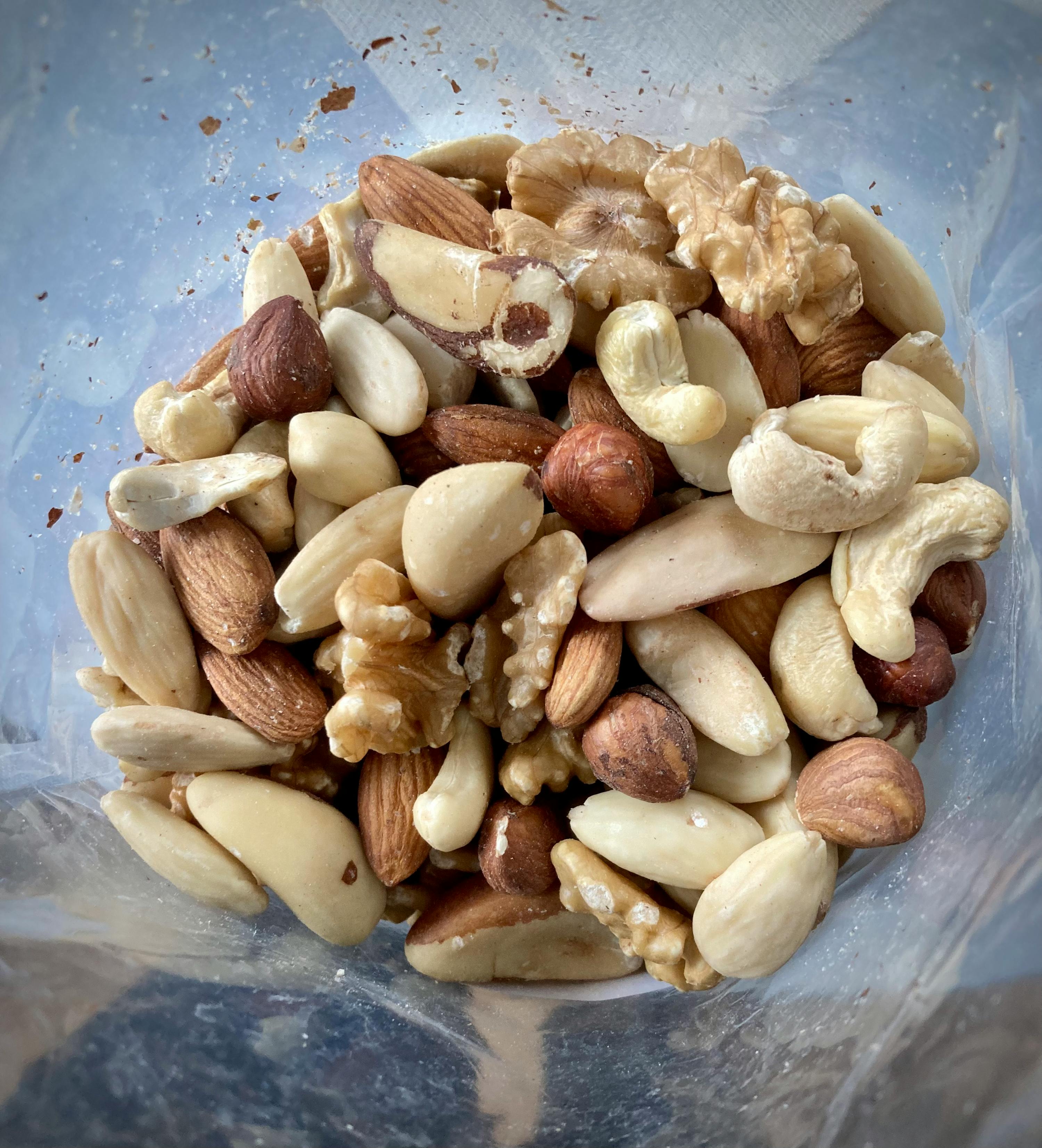 un sac en plastique rempli de noix de cajou et d' amandes