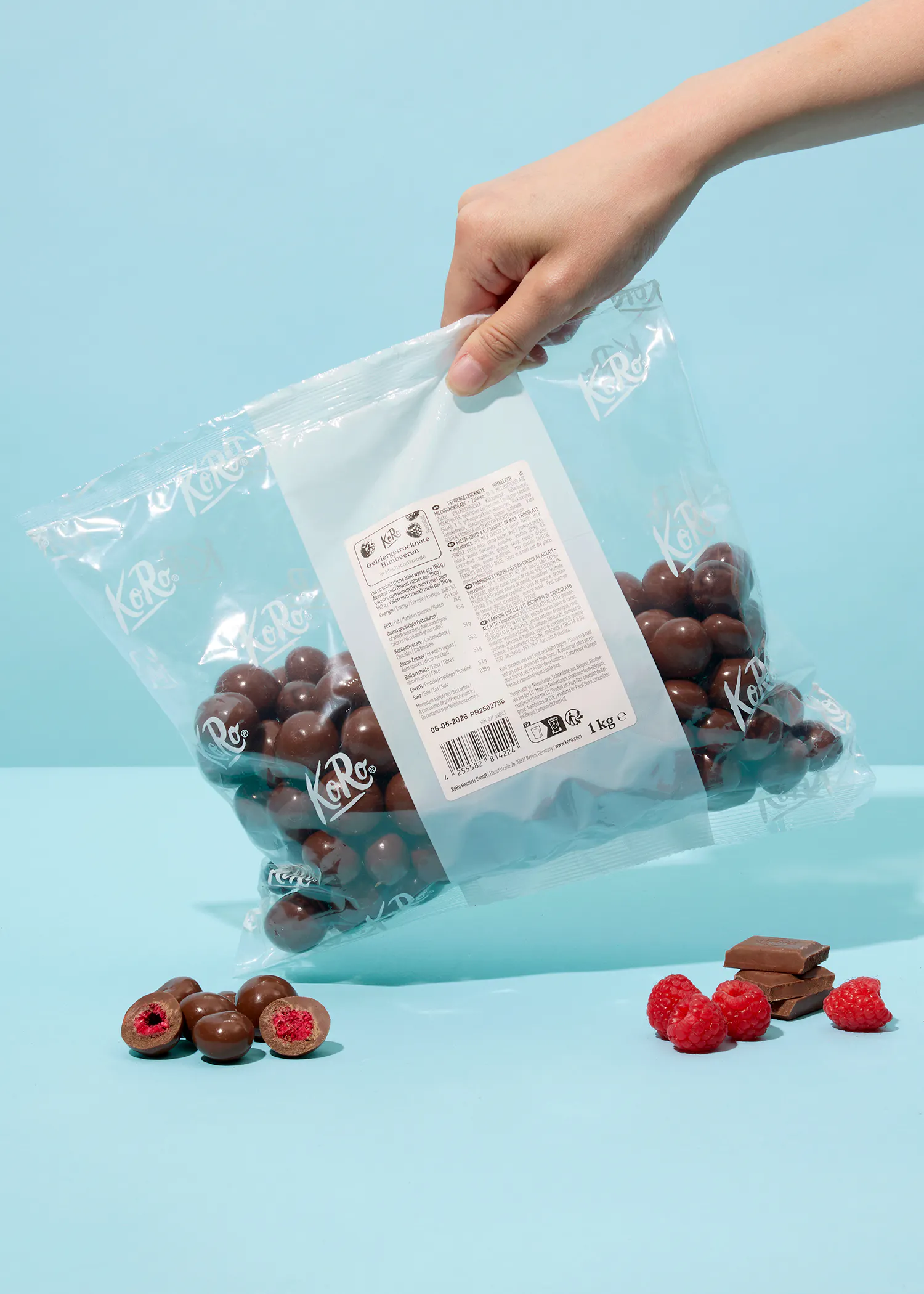 a person is opening a bag of chocolate covered raspberries
