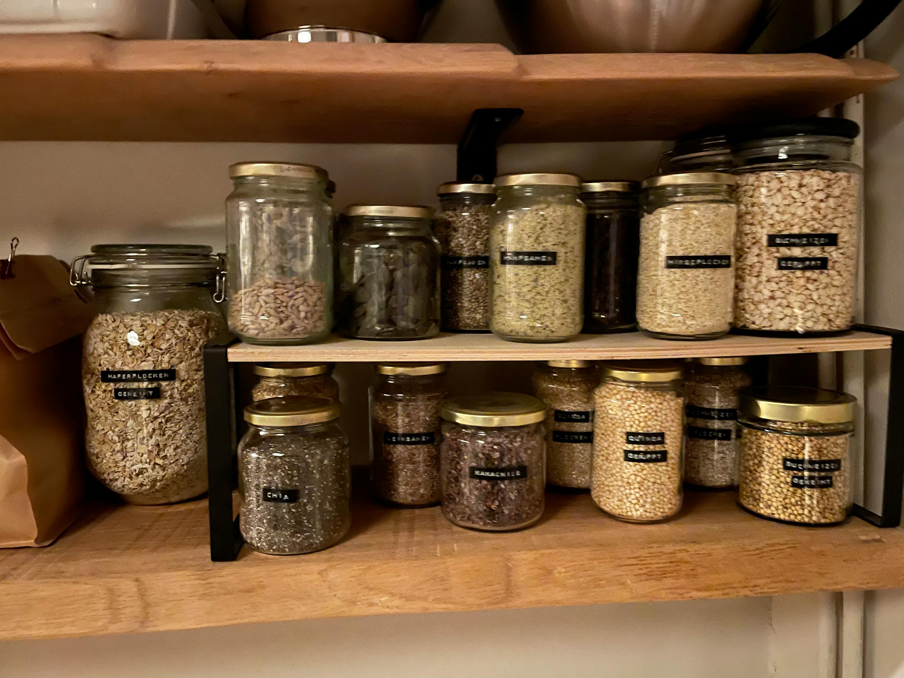 une étagère en bois remplie de bocaux de nourriture dont l' un s'appelle chia