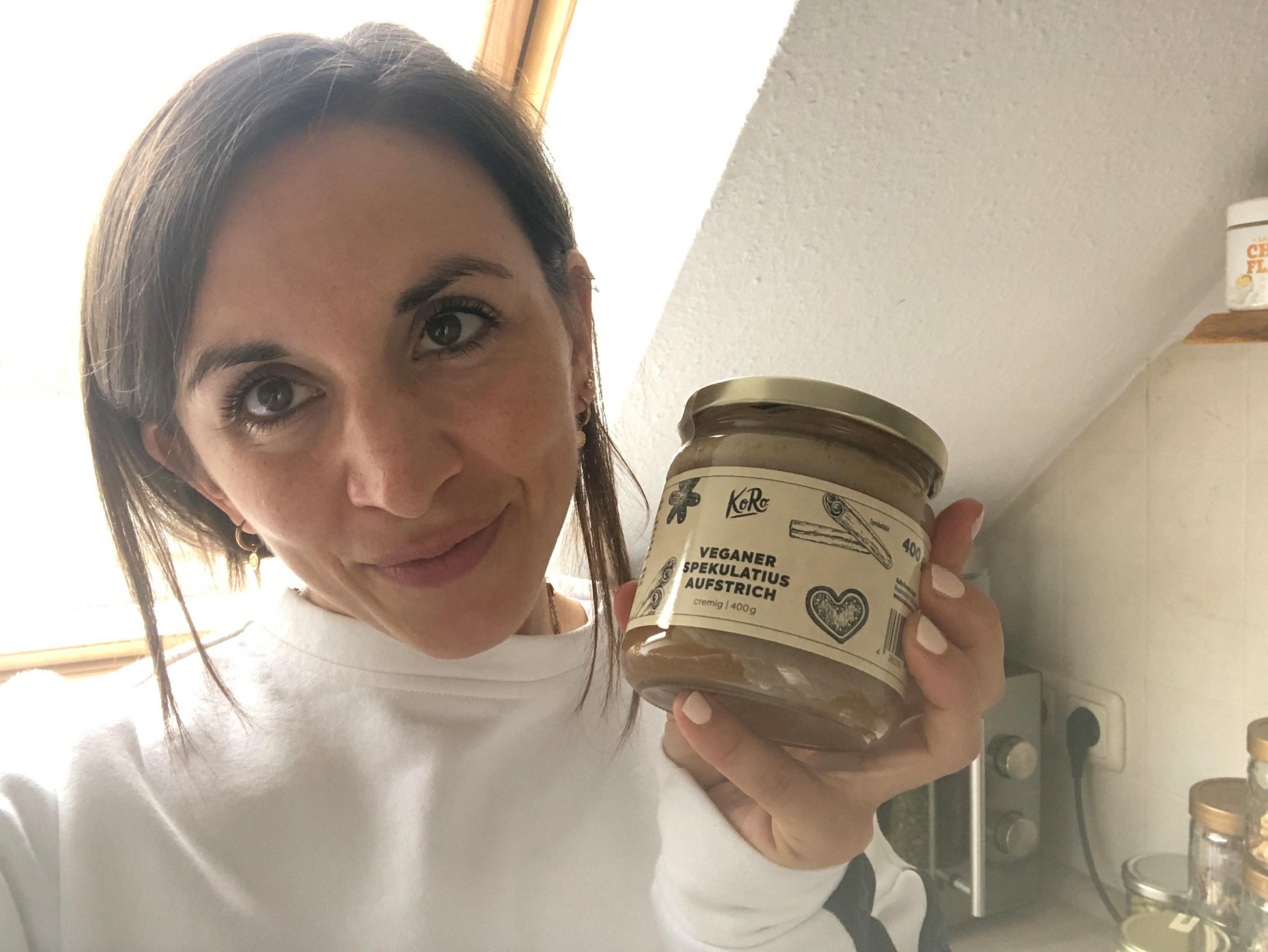 Eine Frau hält ein Glas veganer Nussmus in ihren Händen