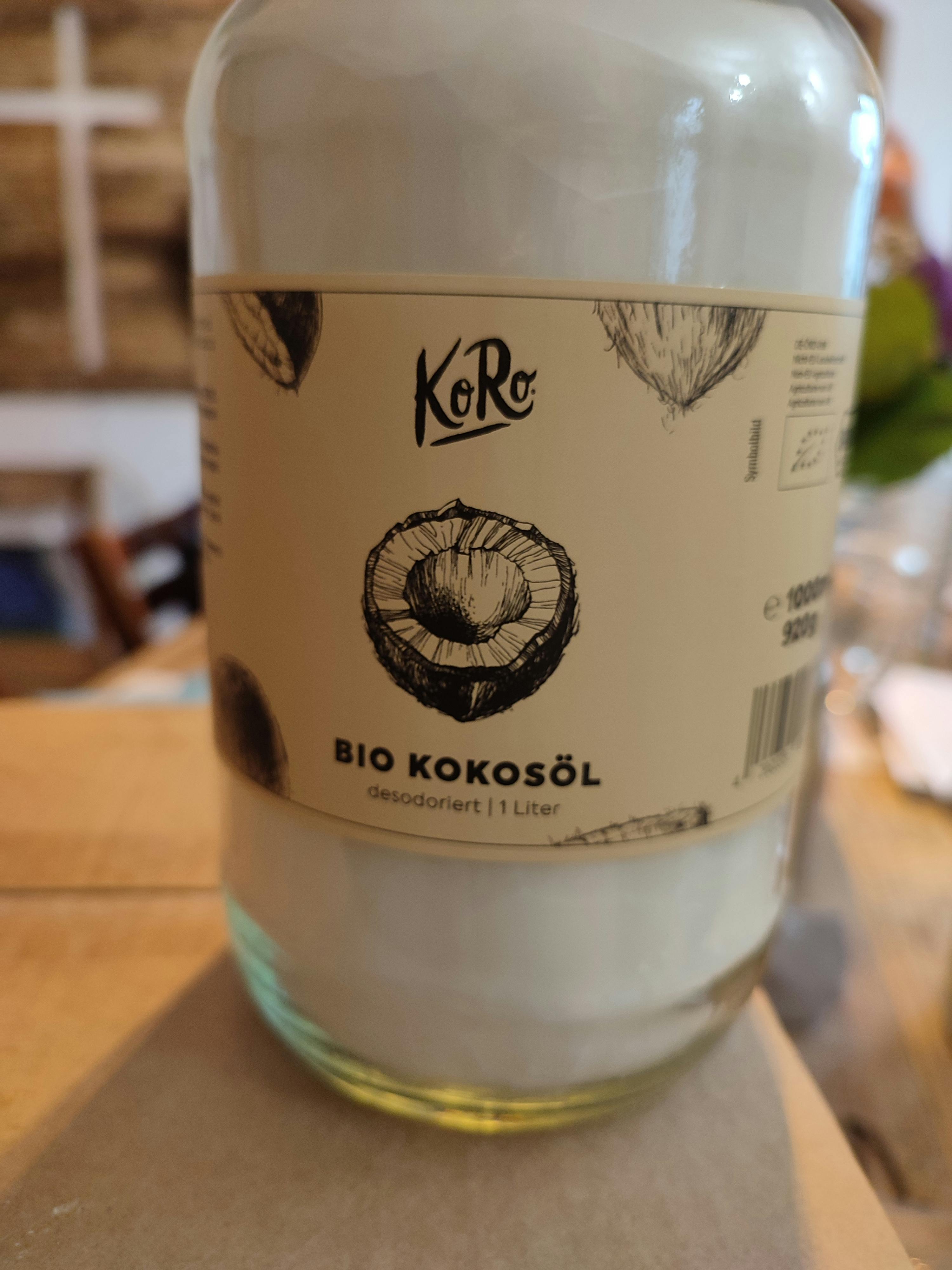 una bottiglia di olio di cocco biologico è seduta su un tavolo di legno