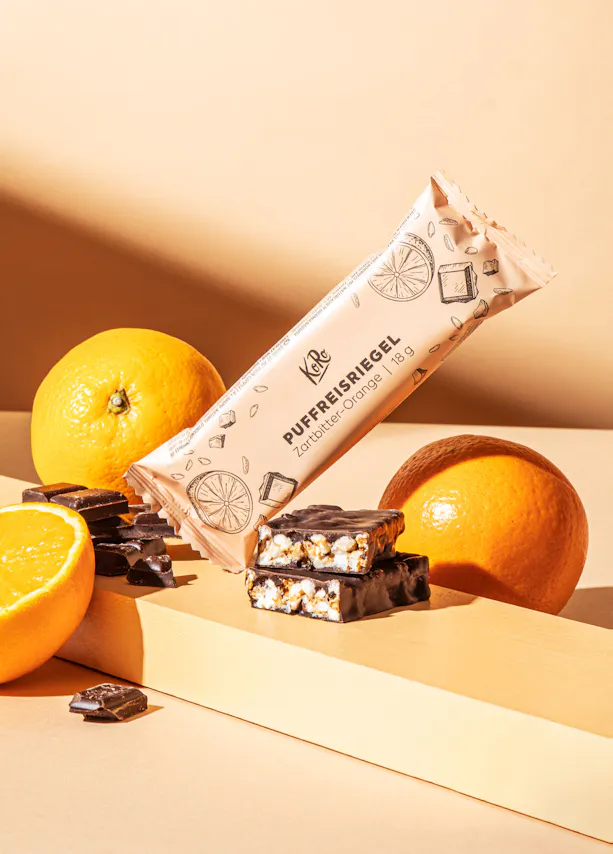 une barre de chocolat est posée sur une table à côté d' oranges et de chocolat