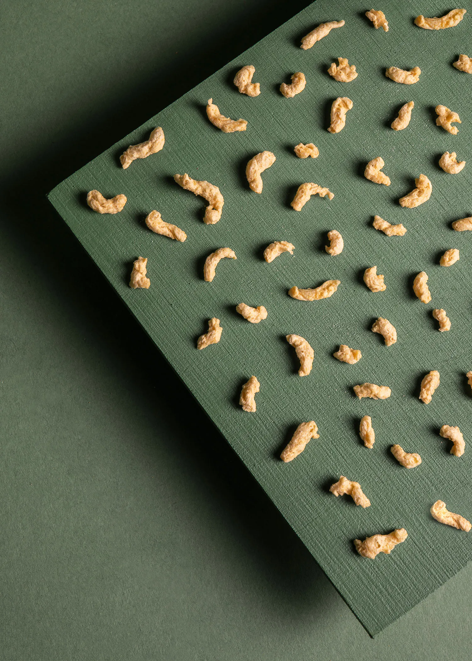 a green surface with a pattern of noodles on it