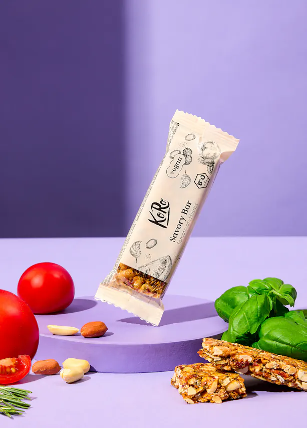 une barre savoureuse est posée sur une table violette entourée de tomates et de basilic