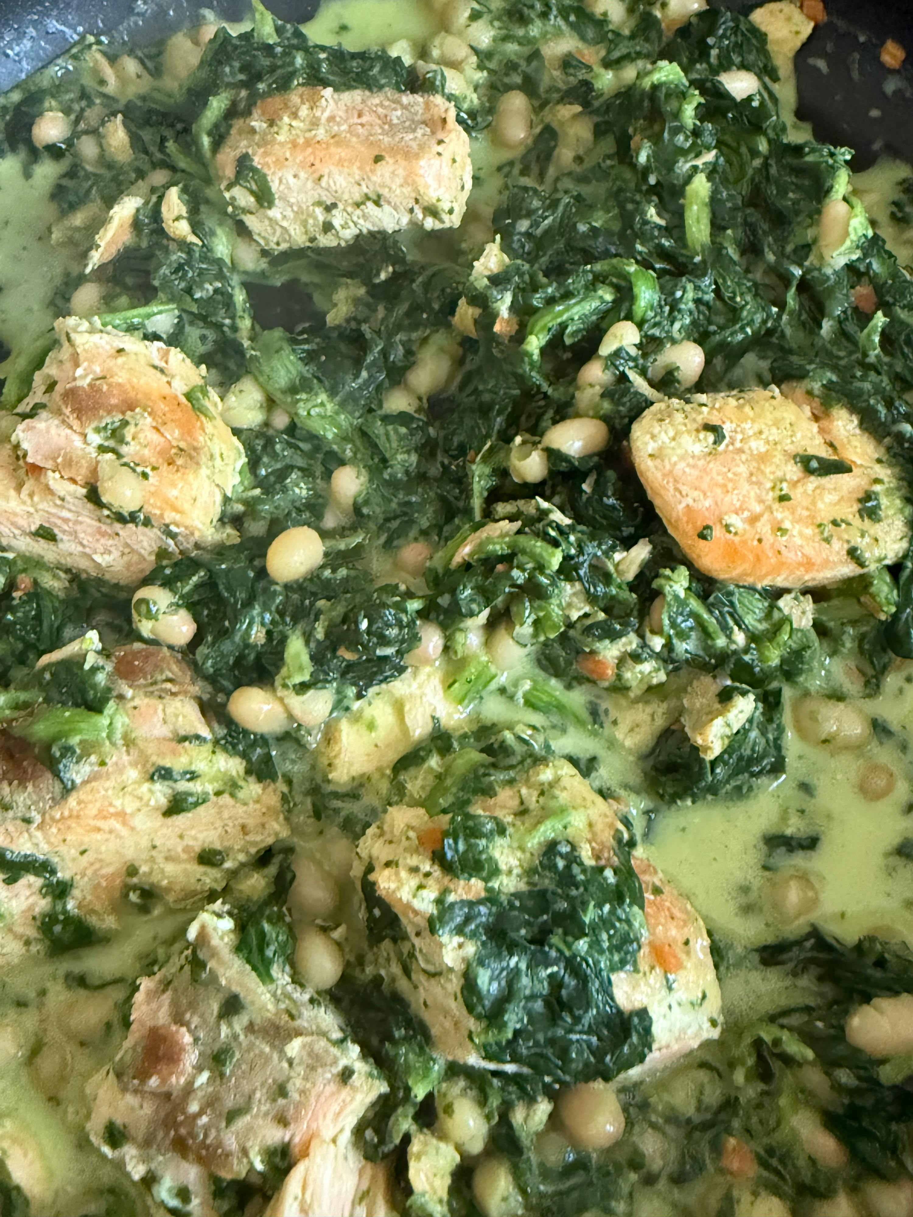 eine Nahaufnahme einer Pfanne mit Essen mit Spinat und Bohnen