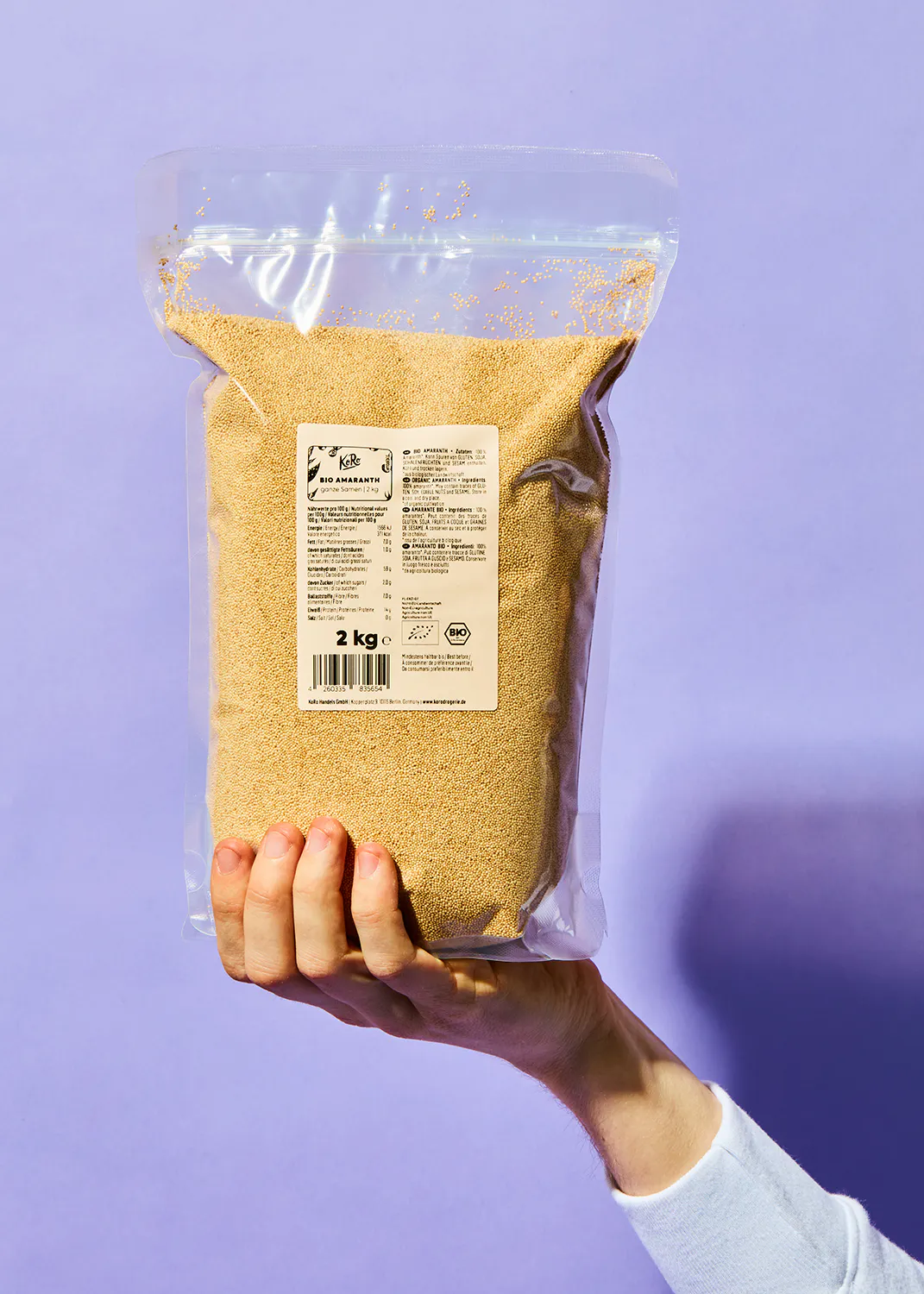 une personne tient un sac de 2 kg de farine