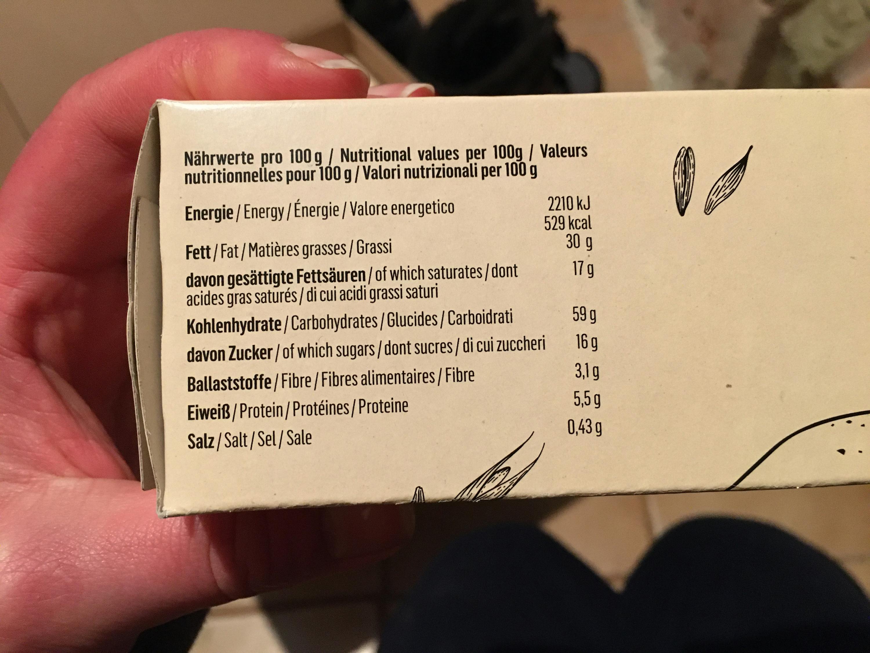 eine Person hält eine Schachtel mit einer nährwertangabe