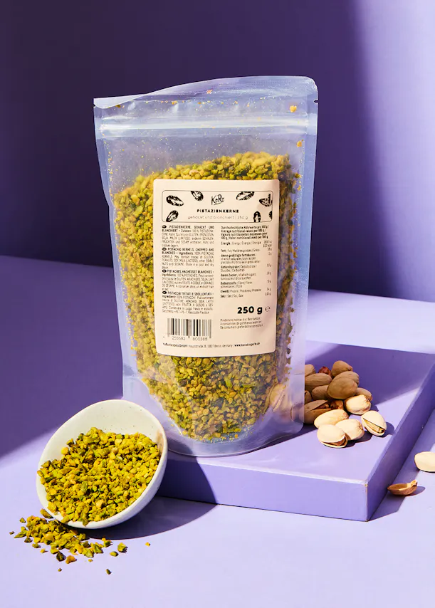 eine Plastiktüte mit pistazienkernen steht neben einer Schüssel pistazienkerne