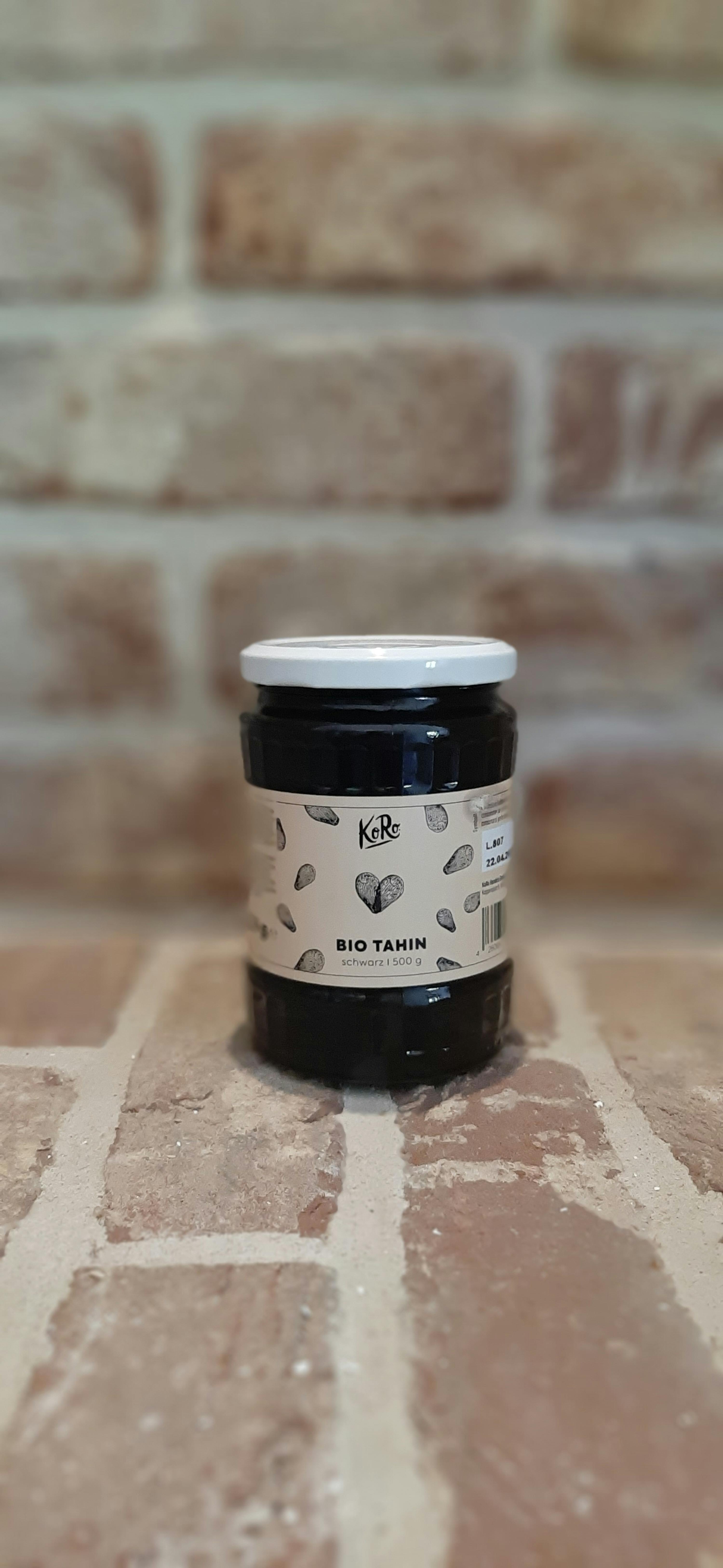 a jar of kr bio tahin sits on a brick wall