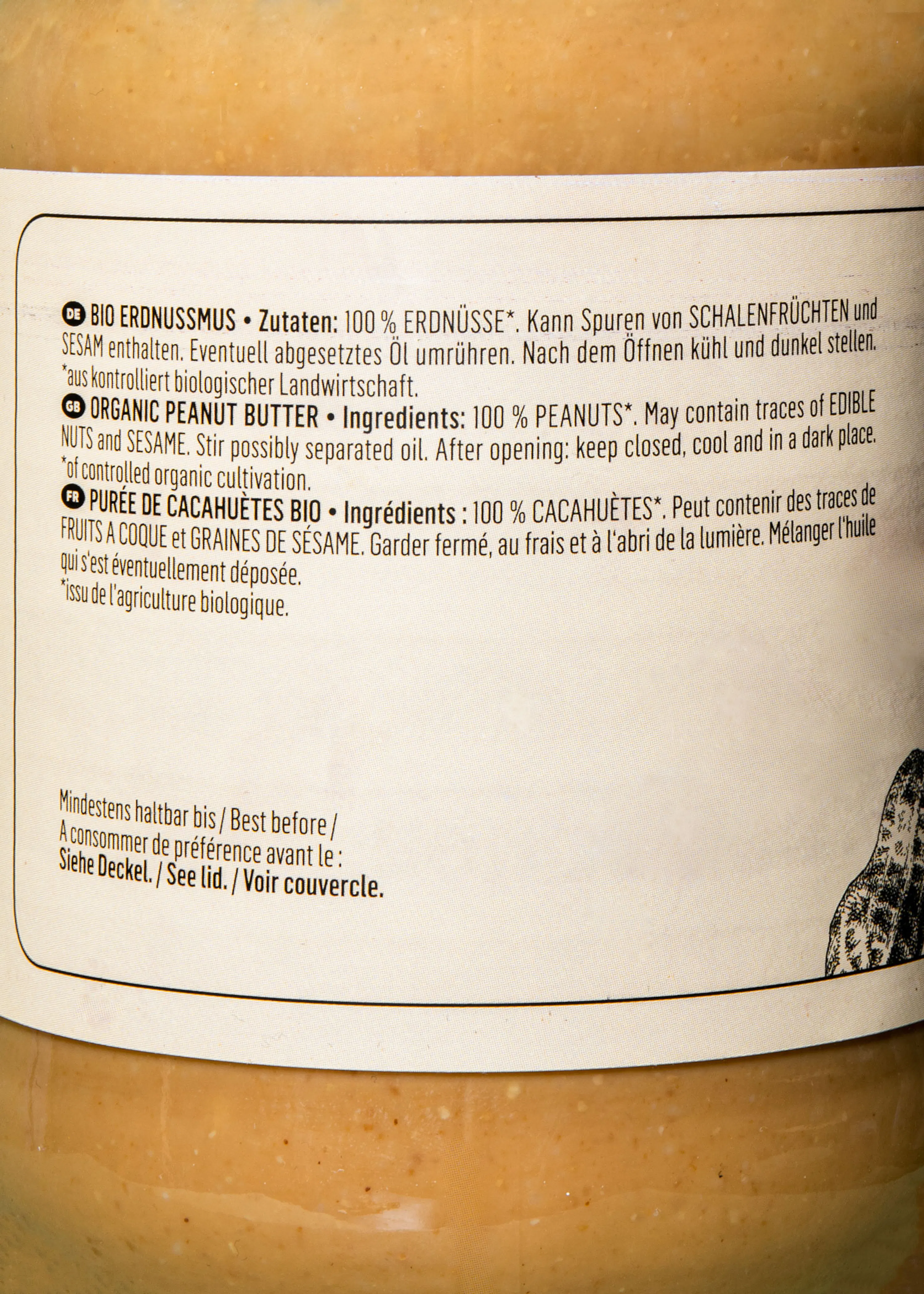 ein produktetikett für erdnussbutter mit zutaten- und lagerungsinformationen in deutscher, englischer und französischer sprache.