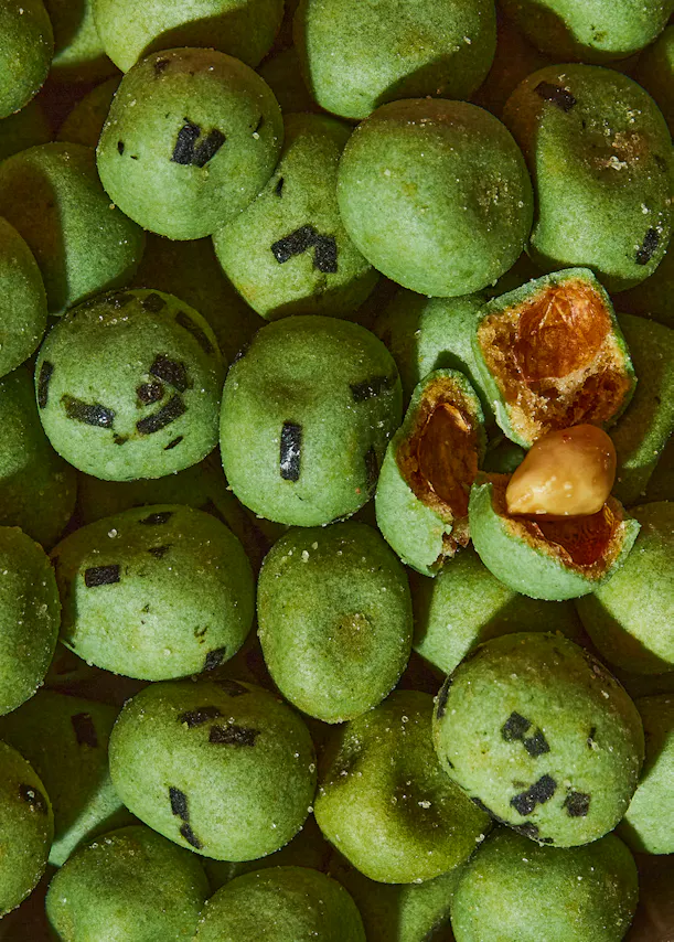 a pile of green balls with a peanut in one of them