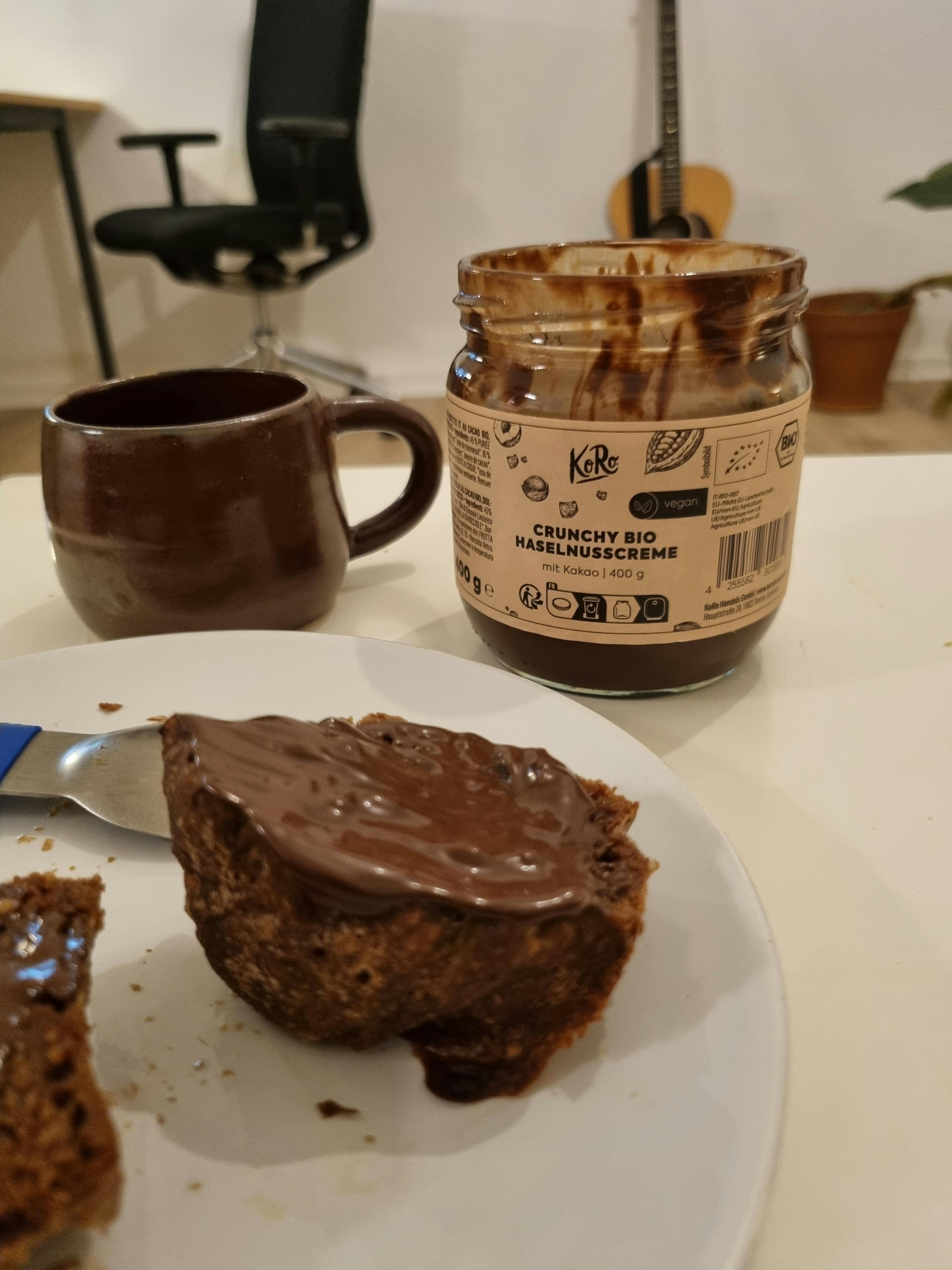 a jar of crunchy bio hazelnut spread next to a plate of cake