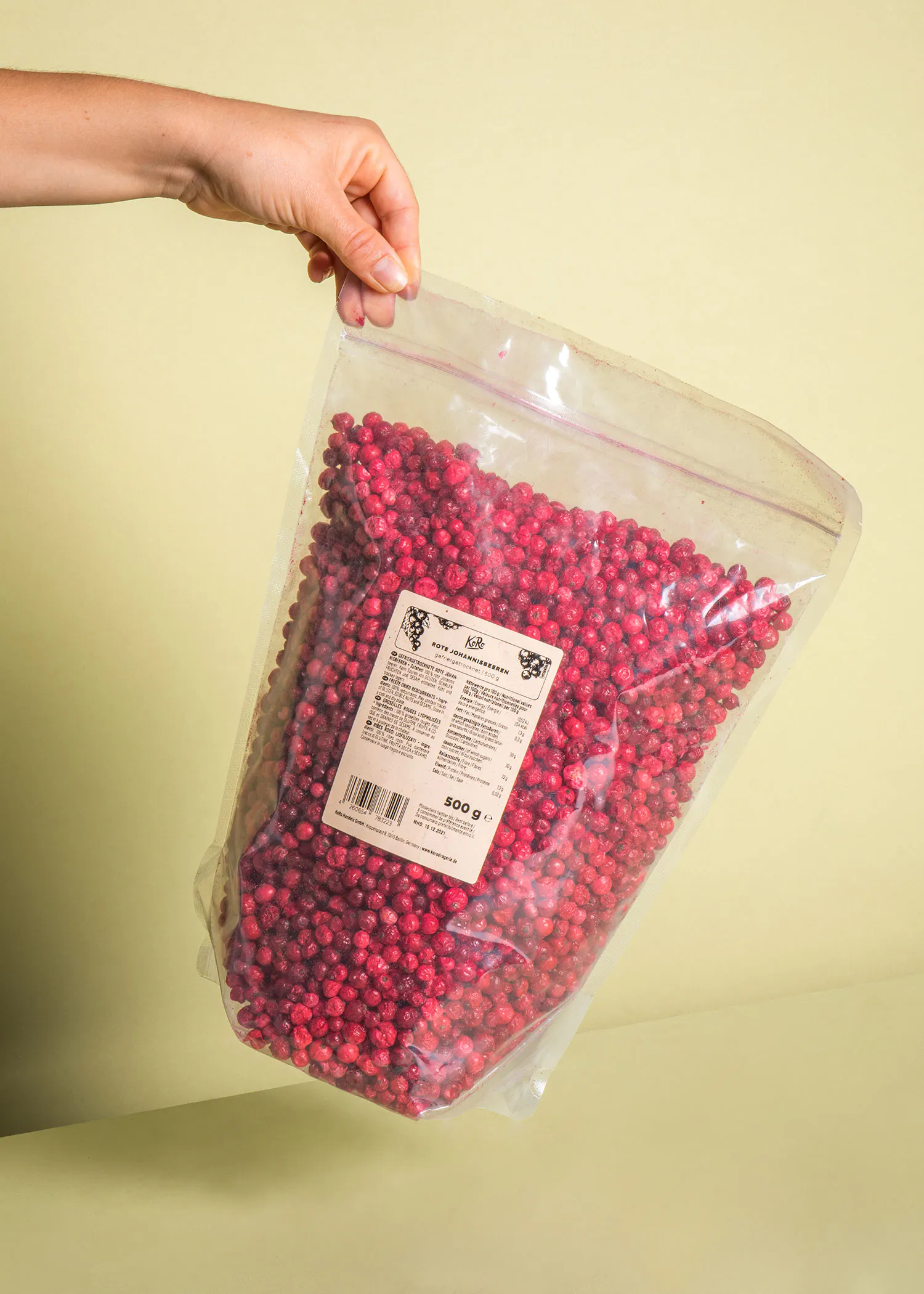 a person holding a bag of dried cranberries