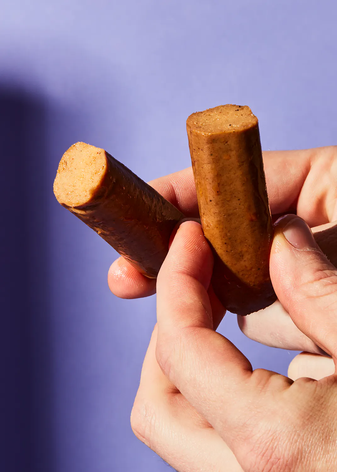 une personne tient deux bâtonnets de nourriture dans leurs mains