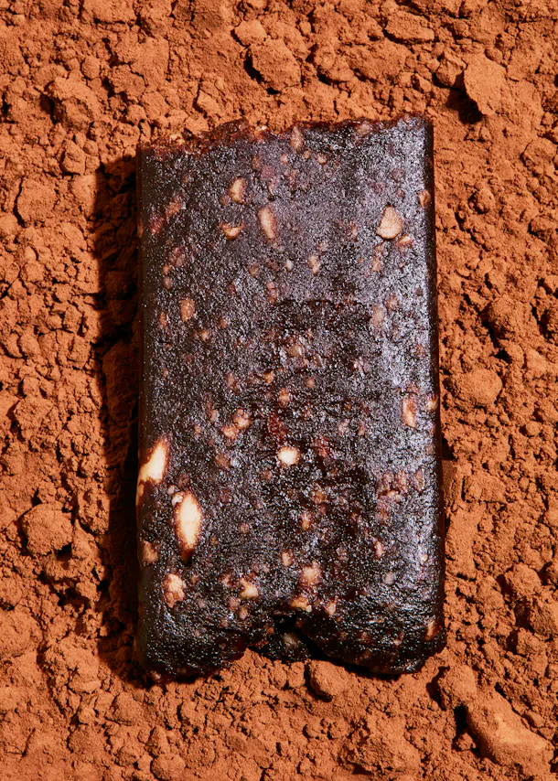 une barre de chocolat est assise sur un tas de poudre de cacao