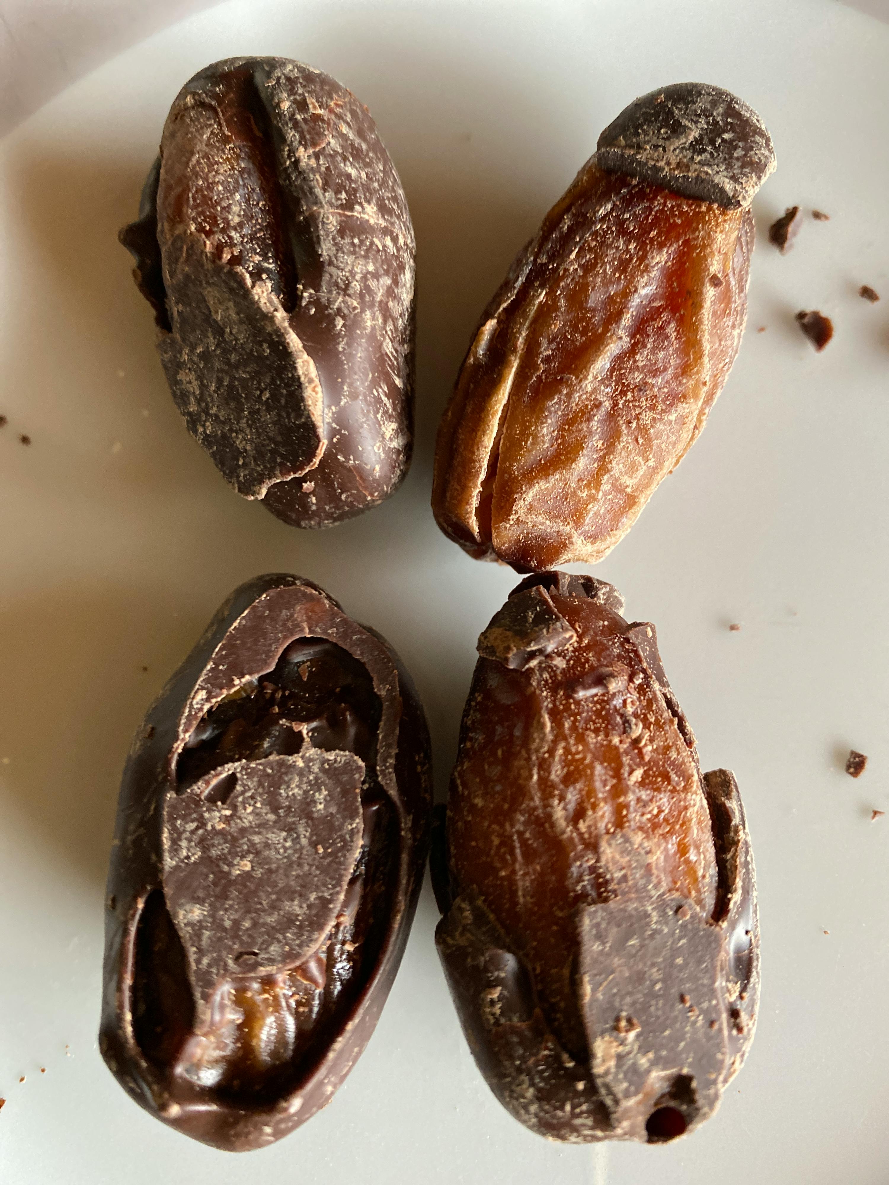 un piatto bianco con quattro noci di cioccolato su di esso