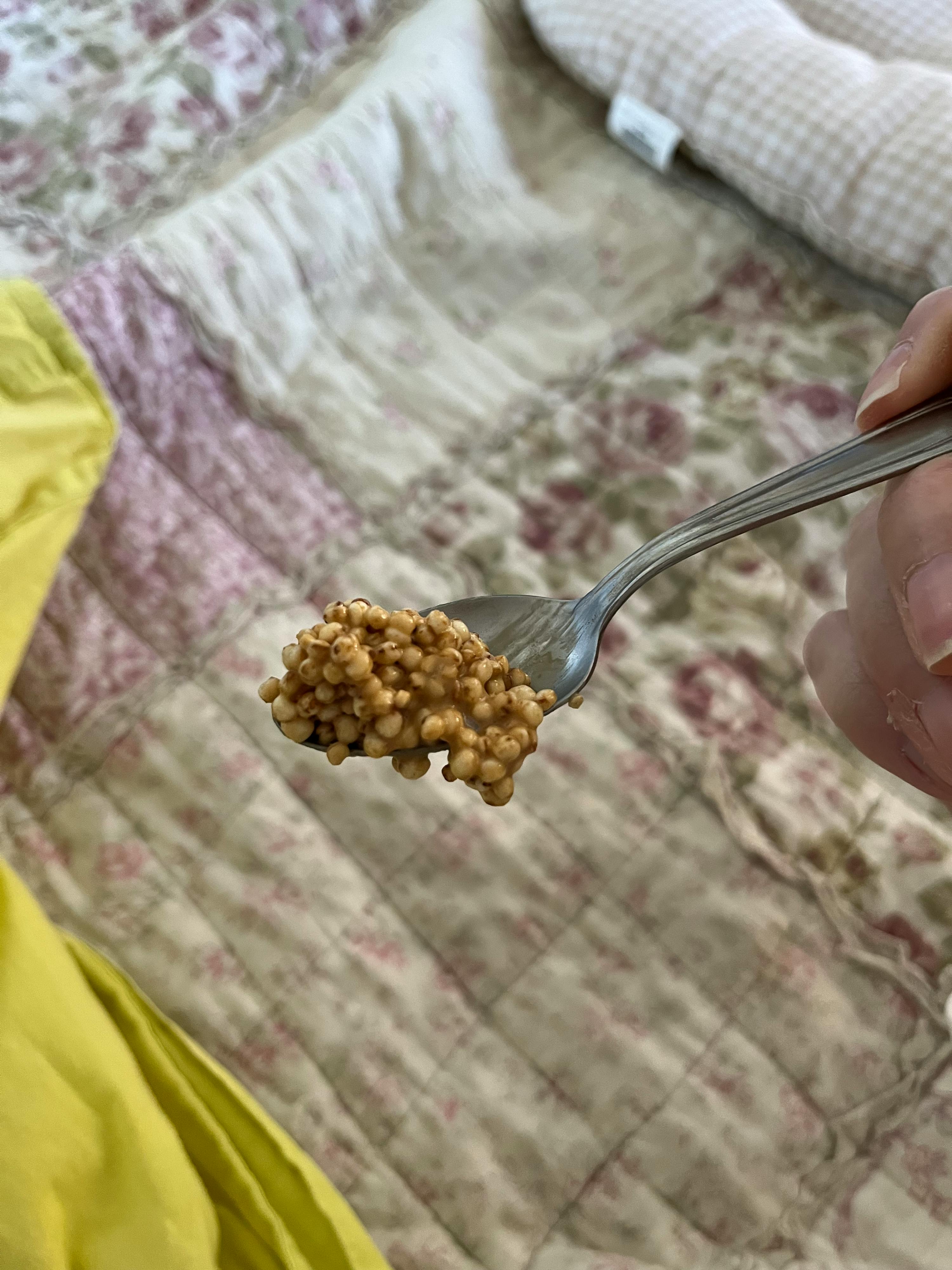 eine Person hält einen Löffel mit einem Stück Essen darauf