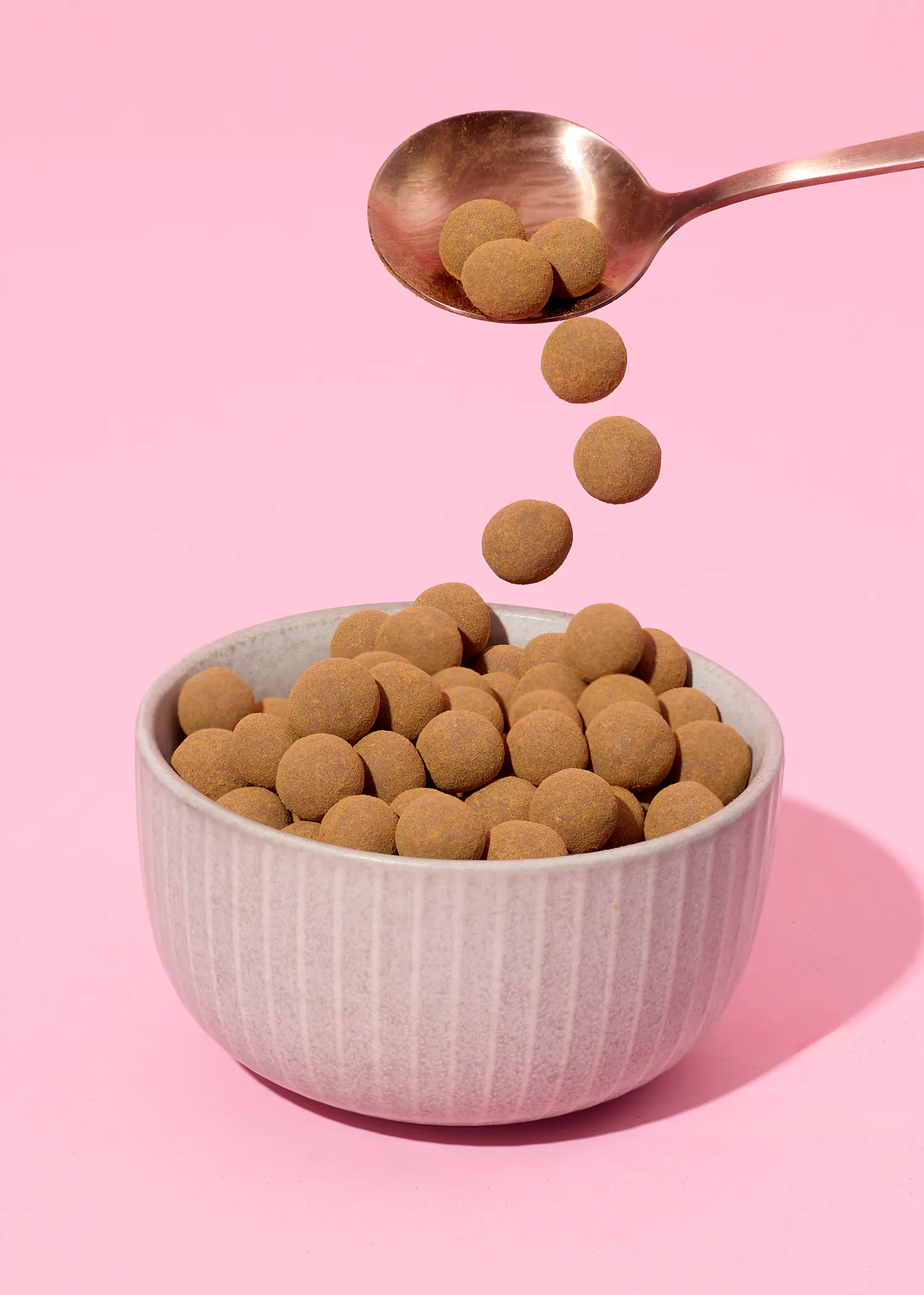 a bowl of chocolate covered almonds with a spoon in it