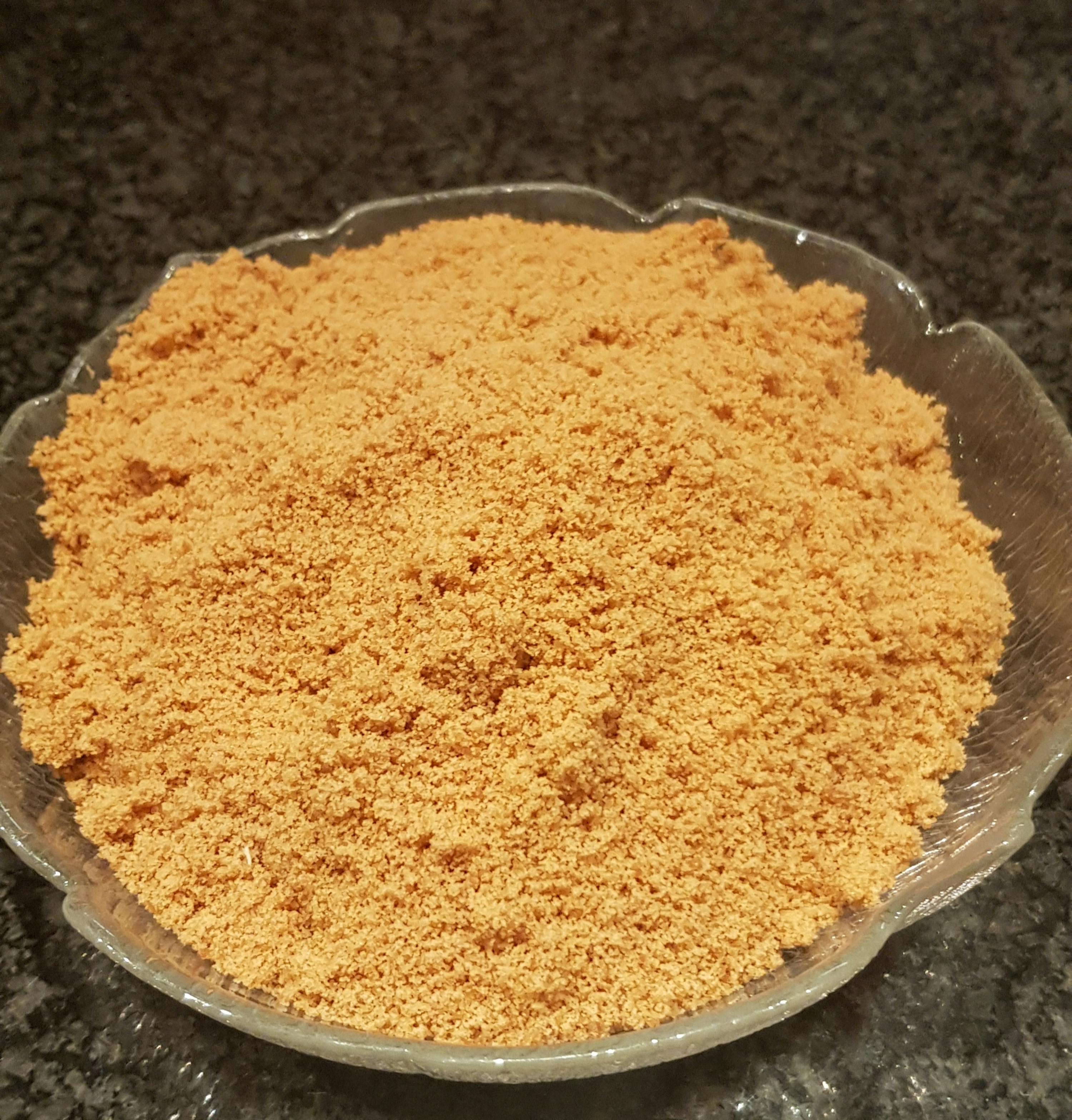 a glass bowl filled with orange powder on a counter