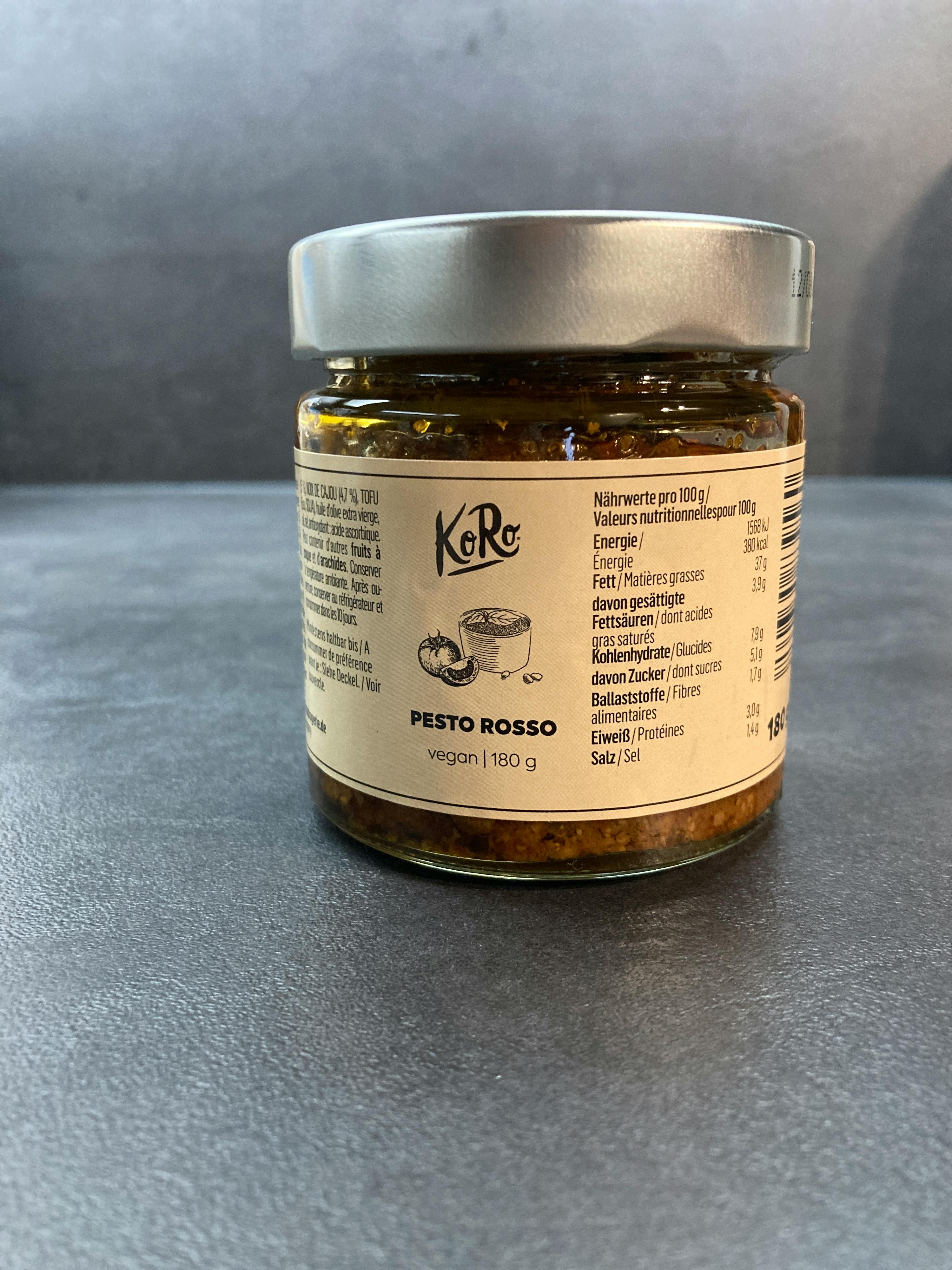 un barattolo di pesto rosso è seduto su un tavolo grigio