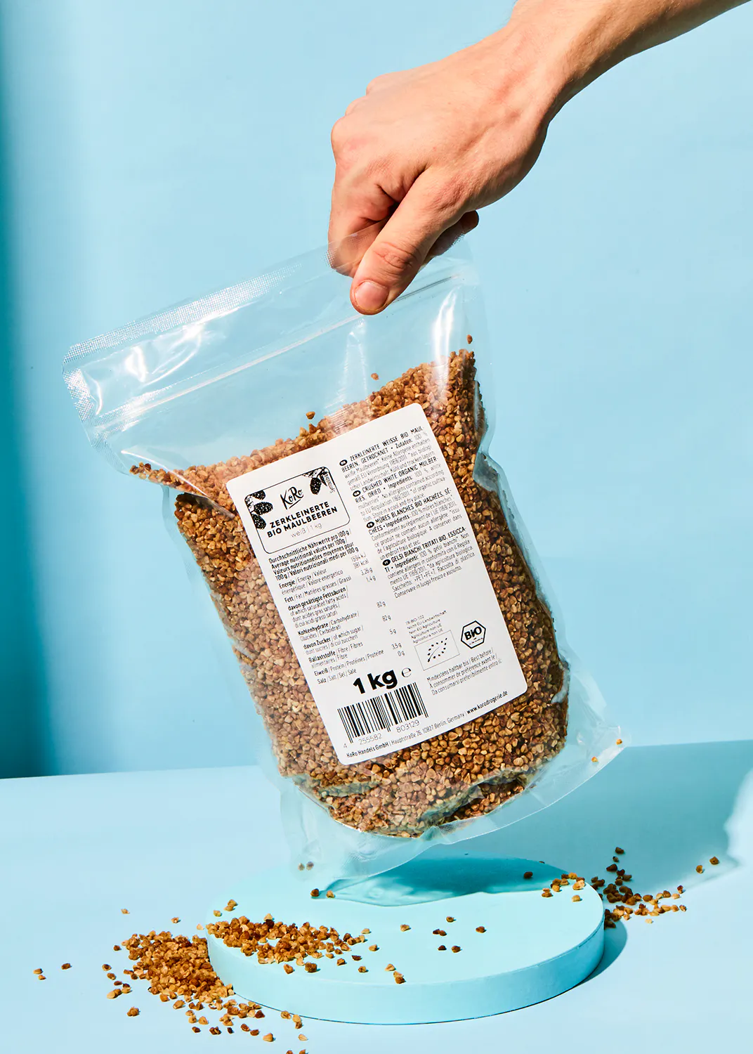 a person is holding a bag of grains that says 1 kg