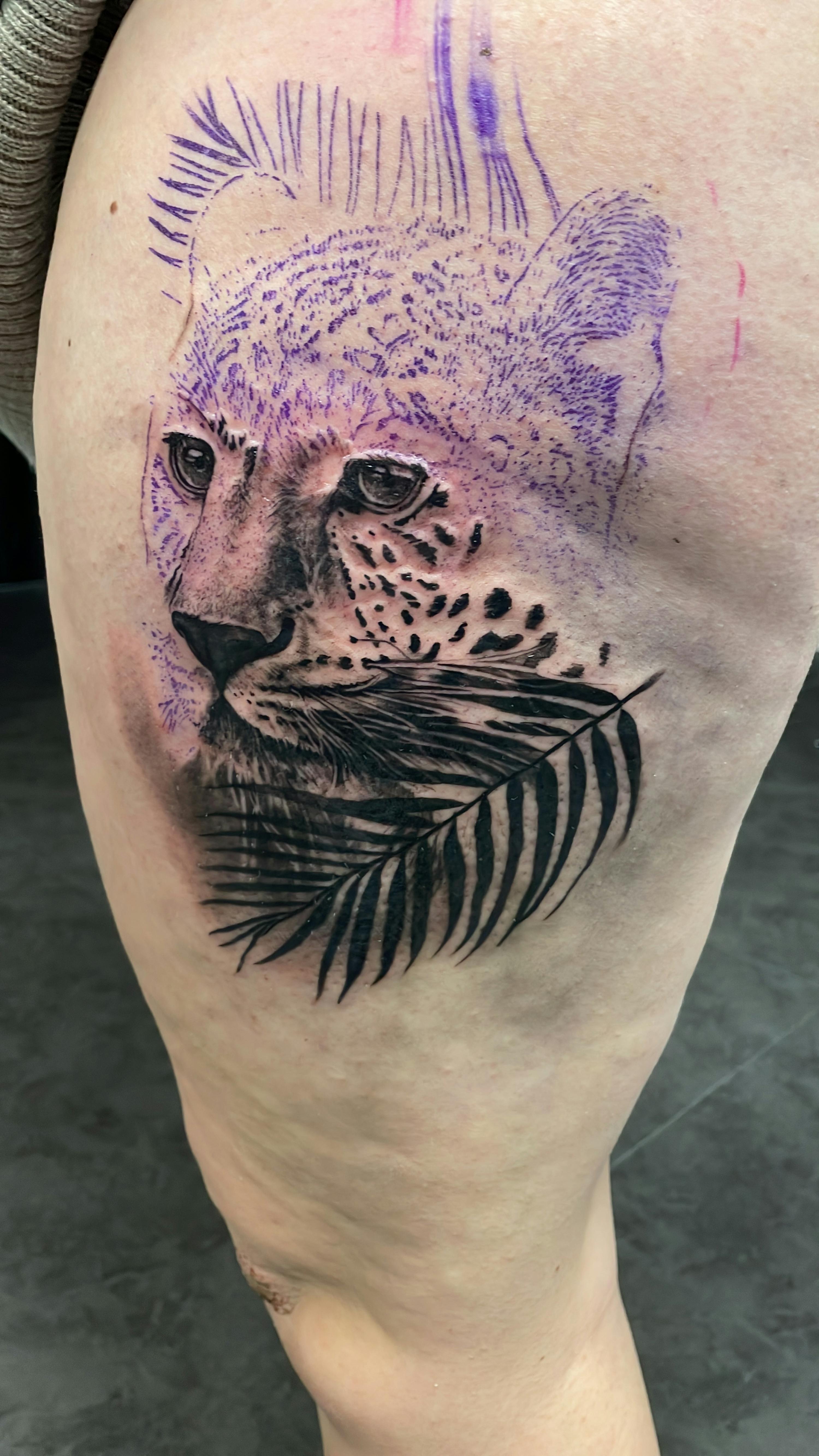 a tattoo of a leopard with a palm leaf behind it