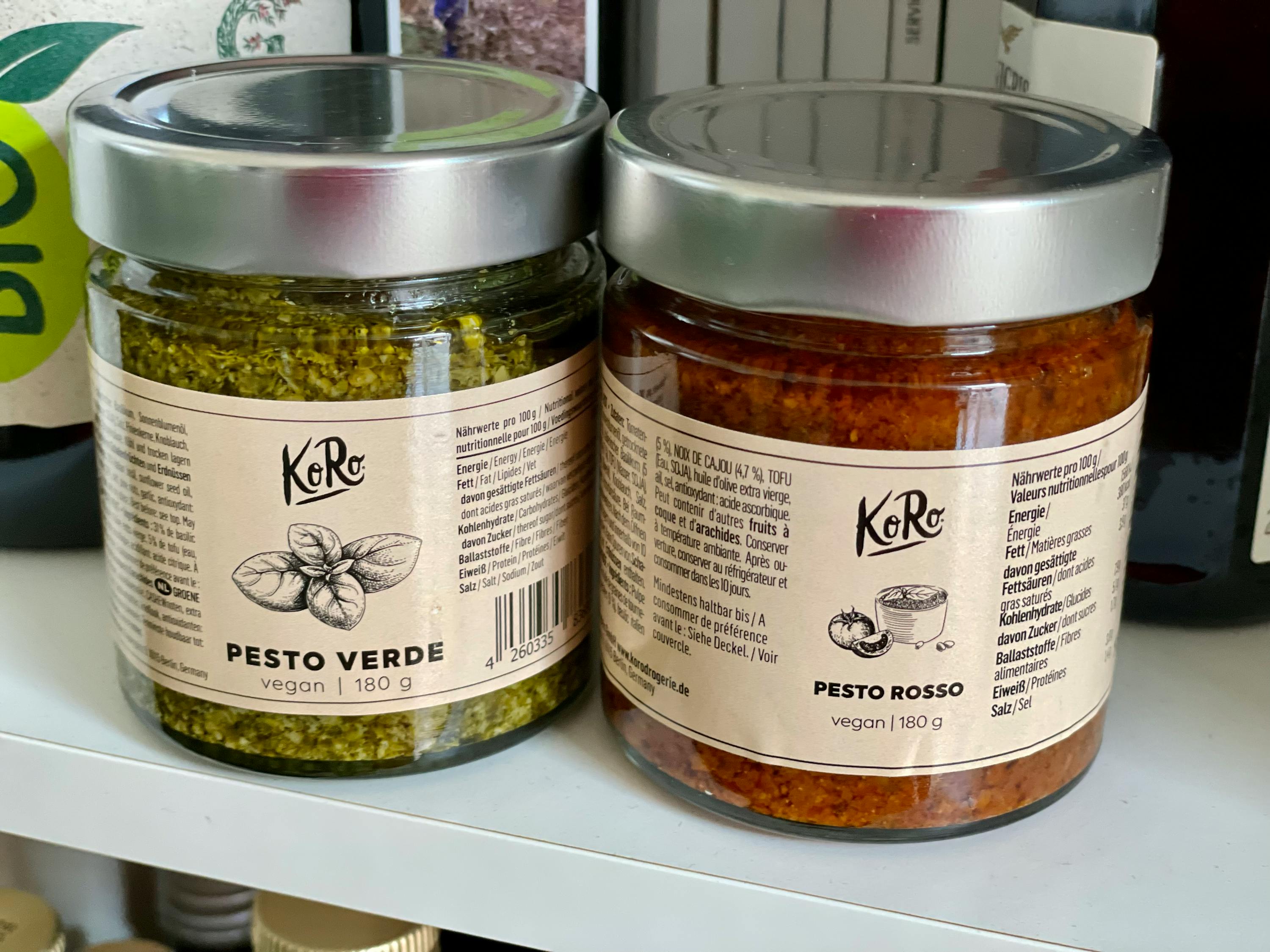 due barattoli di pesto verde e rosso sono seduti uno accanto all'altro