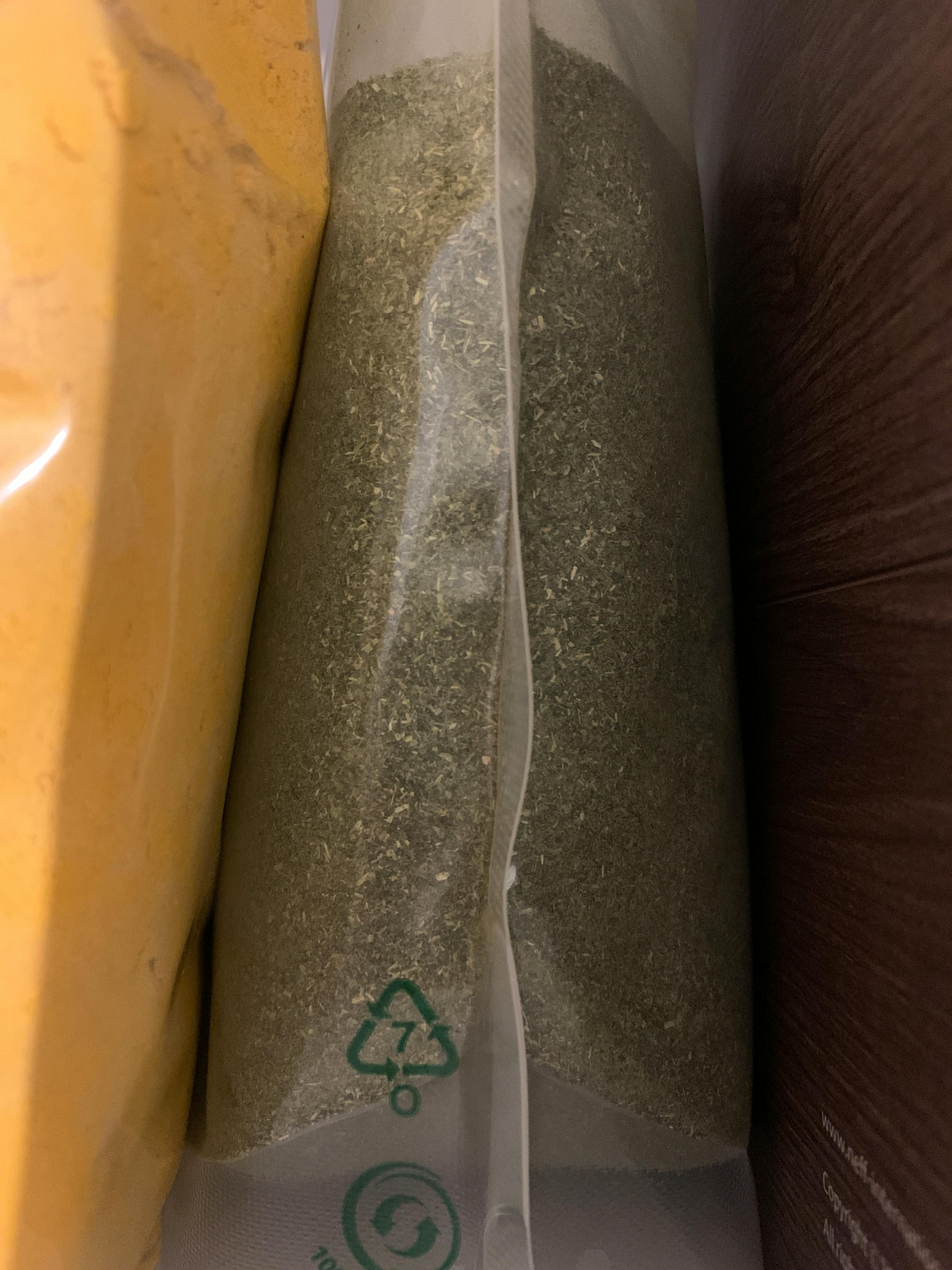 a bag of dried herbs has a green recycling symbol on it